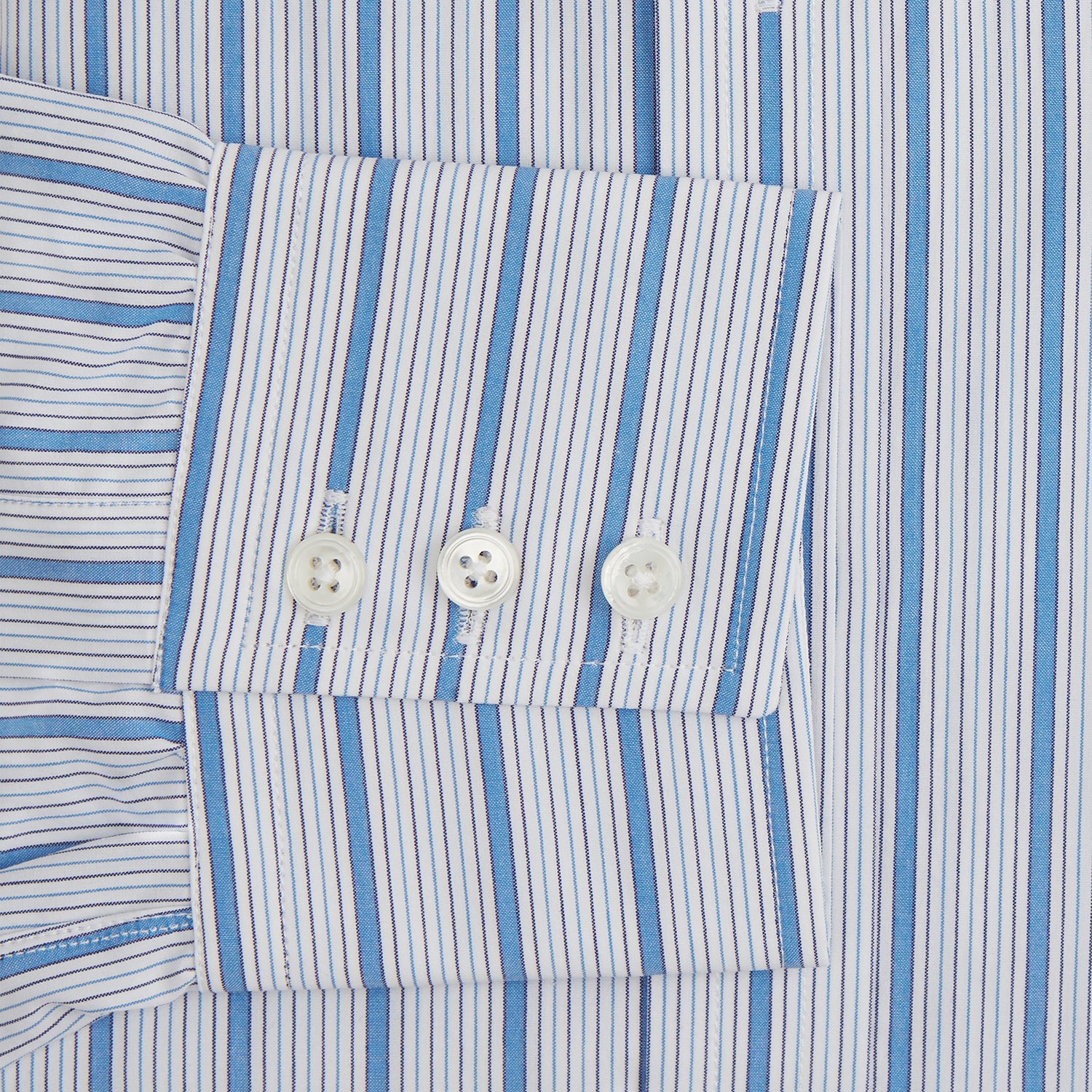 View 3 of product The Turnbull & Asser Blue Multi Track Stripe Mayfair Shirt is a button-up, long-sleeve shirt in white organic cotton with blue vertical stripes, classic collar, and buttoned cuffs.