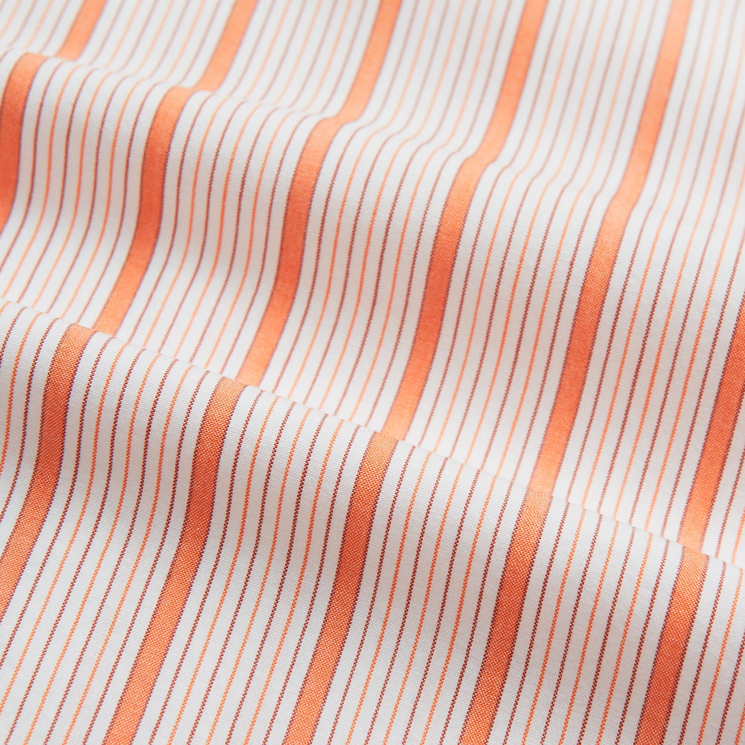 View 5 of product The Orange Graph Overlay Check Mayfair Shirt by Turnbull & Asser is a long-sleeved organic cotton button-up with orange and white stripes, a collar, and wide cuffs—ideal for elevating your wardrobe. Shown against a white background.