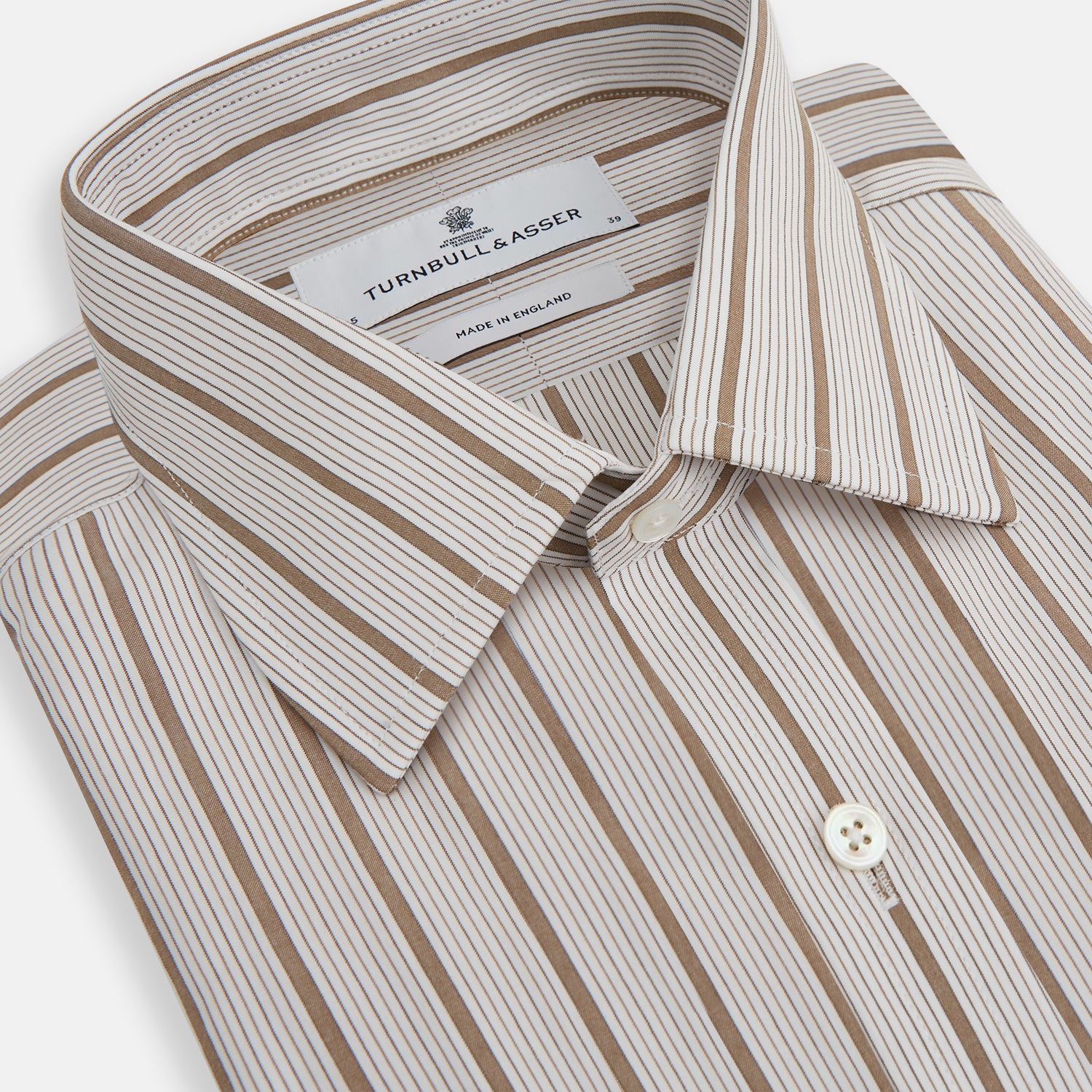 View 2 of product The Brown Multi Track Stripe Mayfair Shirt by Turnbull & Asser is a long-sleeved, collared, button-up in organic cotton with vertical brown and white stripes, classic fit, cuffs, and timeless style—shown on a plain white background.