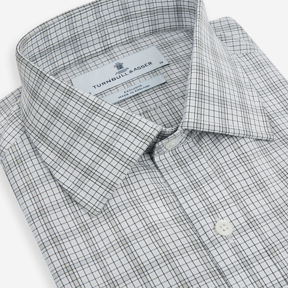 The Turnbull & Asser Grey Fine Multi Graph Check Mayfair Shirt features a breathable cotton fabric, classic T&A collar, white buttons, and a subtle plaid pattern, displayed on a white background.