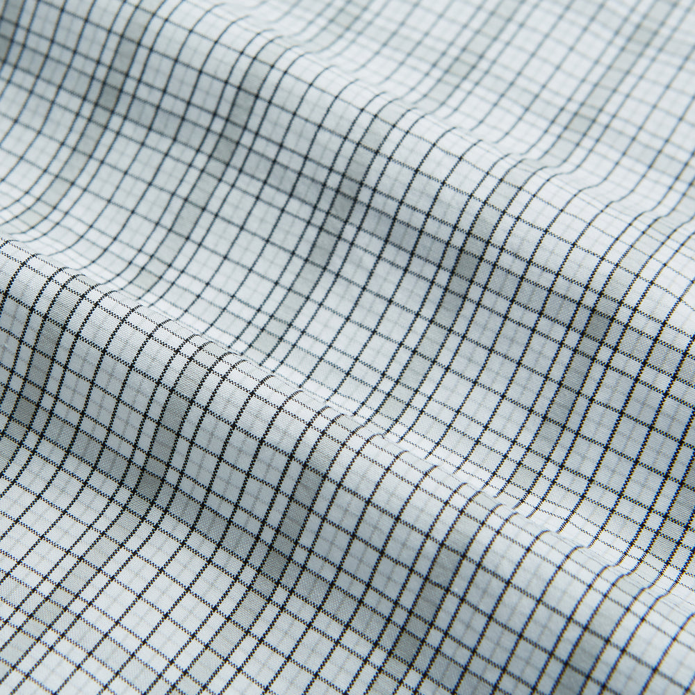 The Turnbull & Asser Grey Fine Multi Graph Check Mayfair Shirt features a breathable cotton fabric, classic T&A collar, white buttons, and a subtle plaid pattern, displayed on a white background.