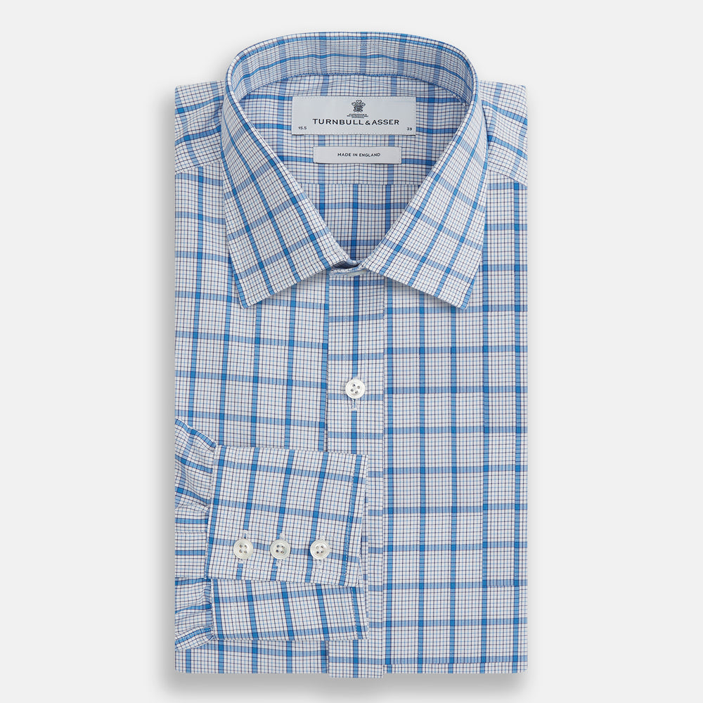 The Turnbull & Asser Blue Graph Overlay Check Mayfair Shirt features long sleeves, a spread collar, buttoned cuffs, and a blue and white plaid pattern, shown against a plain white background.