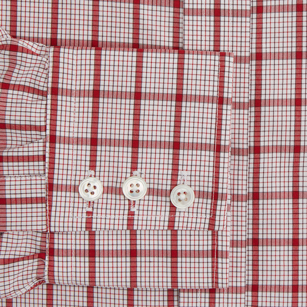 The Red Graph Overlay Check Mayfair Shirt by Turnbull & Asser is a long-sleeved, button-up shirt with a white base and red check pattern, featuring a collar and buttoned cuffs. Displayed on a plain white background.