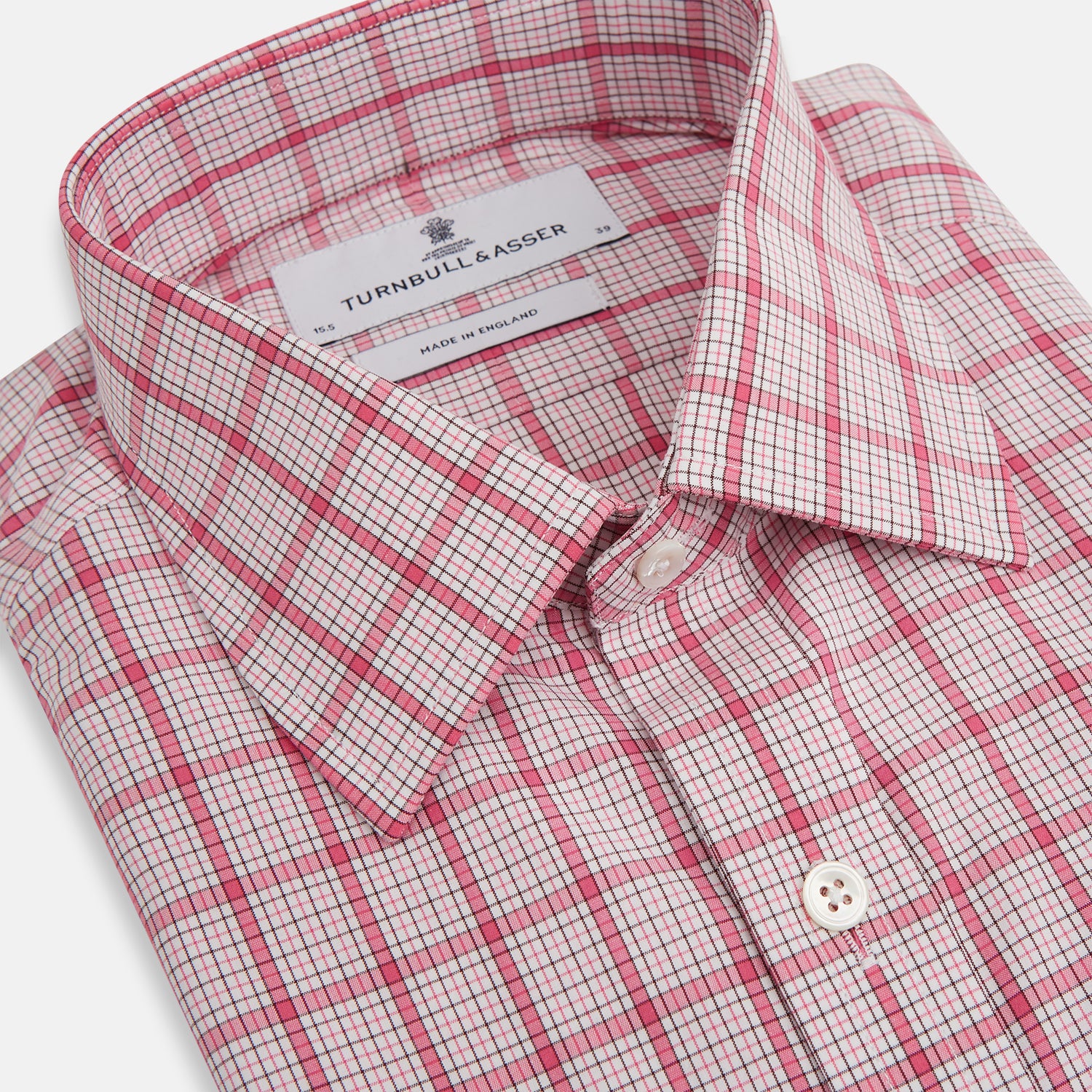 View 2 of product The Turnbull & Asser Pink Graph Overlay Check Mayfair Shirt features a classic collar, long sleeves, and a pink check pattern. Crafted from organic cotton, it is showcased against a plain white background.