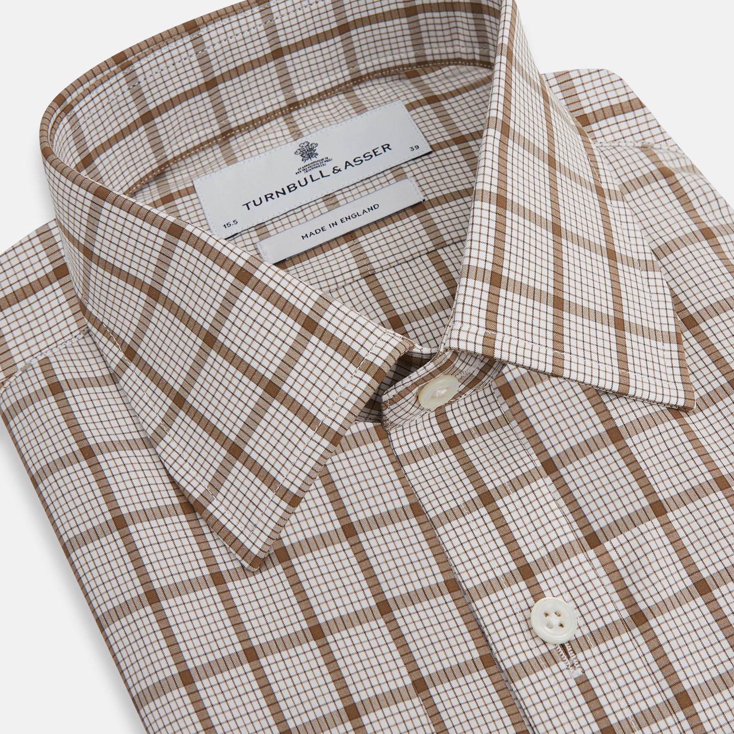 View 2 of product The Turnbull & Asser Brown Graph Overlay Check Mayfair Shirt, an organic cotton long-sleeve button-up with collar and cuffed sleeves, features a beige and white check pattern and is shown laid flat on a white background.