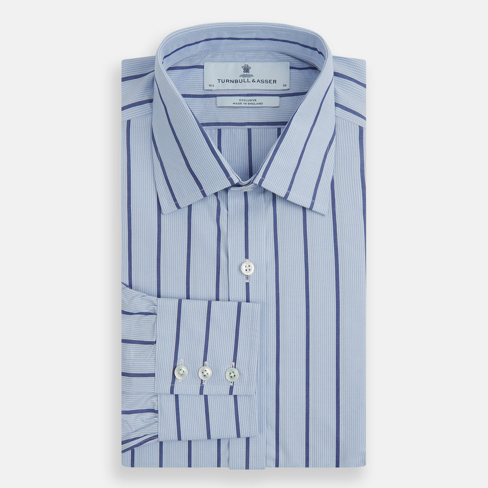 The Blue Track Stripe Mayfair Shirt by Turnbull & Asser features long sleeves, a T&A collar, vertical dark blue stripes on light blue organic cotton, and is shown against a plain white background.