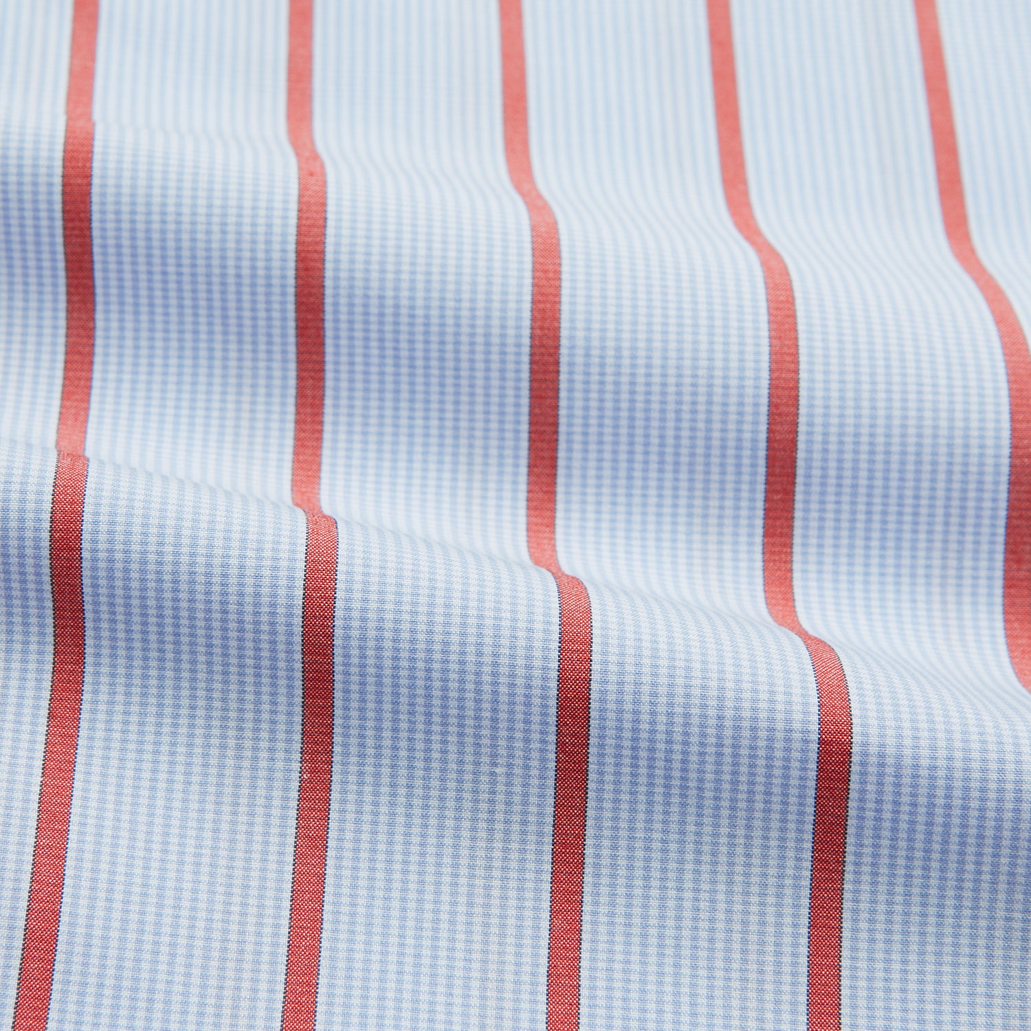 View 5 of product The Red Track Stripe Mayfair Shirt by Turnbull & Asser is made from organic cotton, features a T&A collar, and displays red vertical stripes on light blue, shown against a plain white background.