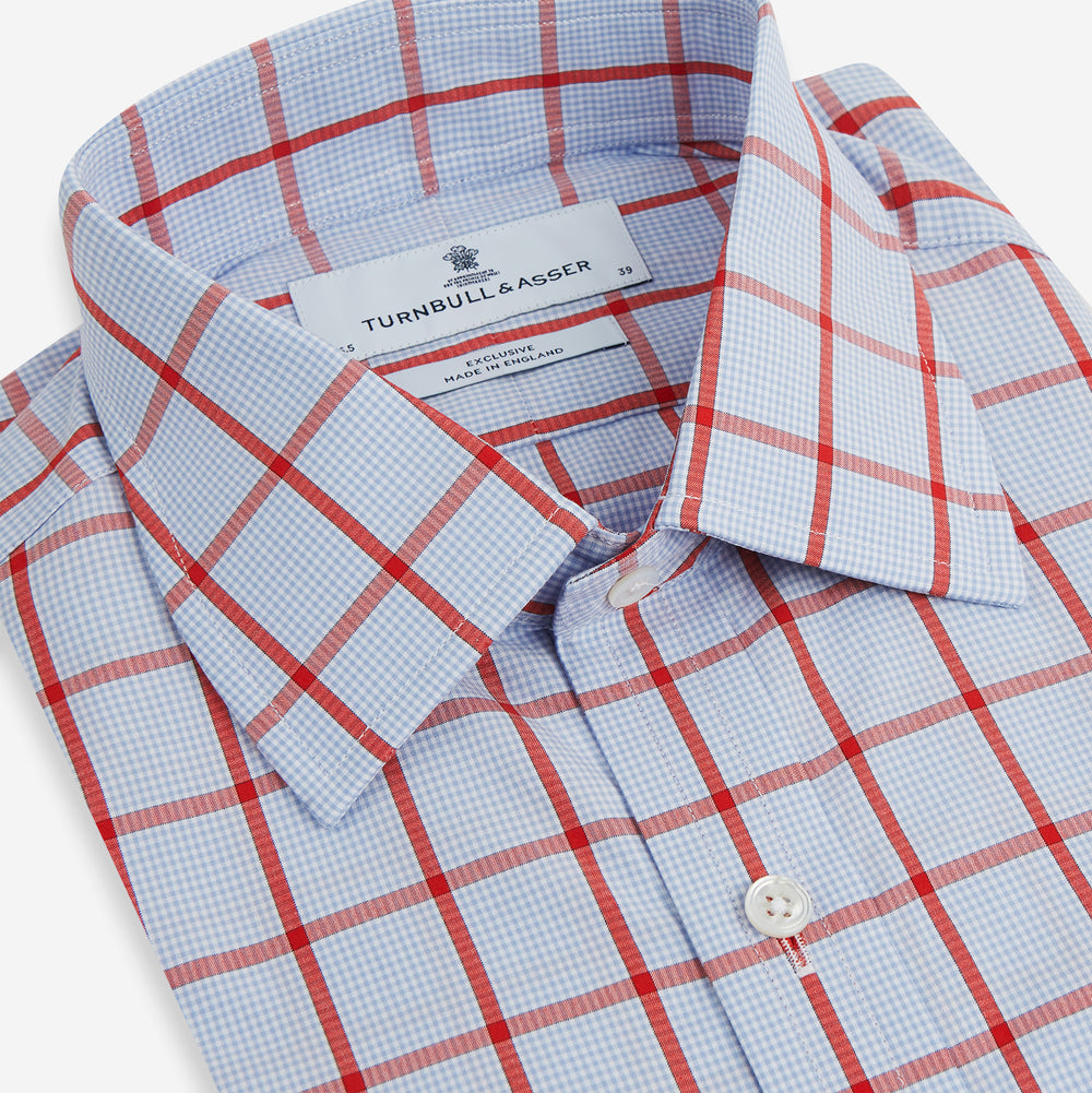 The Red Windowpane Check Mayfair Shirt by Turnbull & Asser is crafted from organic cotton in light blue with red and white windowpane checks, shown against a plain white background.