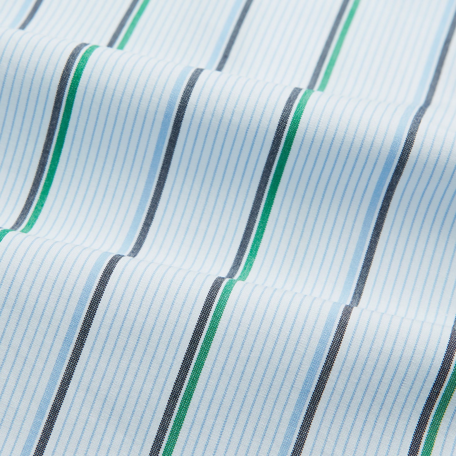 View 5 of product The Blue and Green Shadow Stripe Mayfair Shirt by Turnbull & Asser is a long-sleeved, organic cotton button-up with a T&A collar, buttoned cuffs, and blue and green vertical stripes on white. Features a slightly rounded hem.