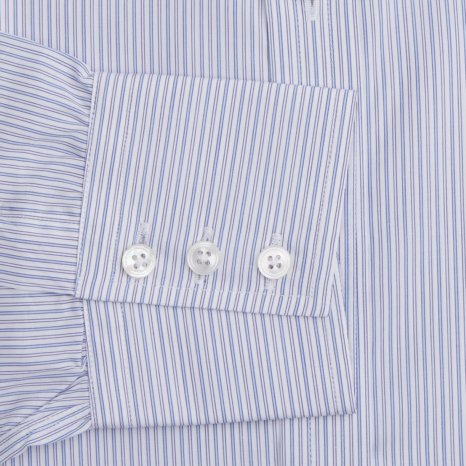 View 3 of product The Light Blue Track Stripe Mayfair Shirt by Turnbull & Asser is a long-sleeve button-up with thin white stripes, pointed collar, and buttoned cuffs. Expertly crafted from Egyptian cotton, it's shown laid flat on a white background.