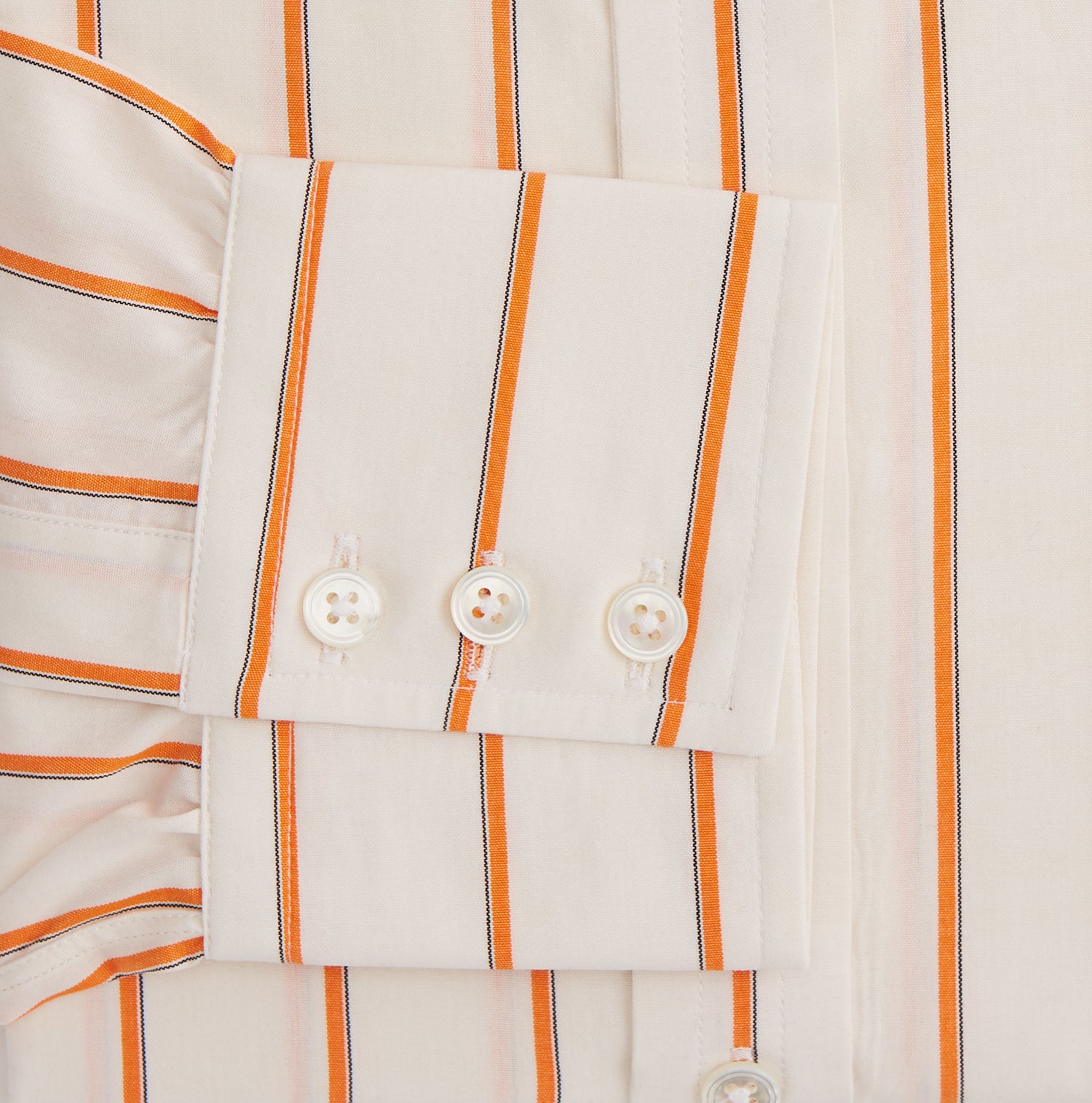 View 3 of product The Orange Track Stripe Mayfair Shirt by Turnbull & Asser features a white base with vertical orange stripes in breathable cotton, plus contrasting horizontal-striped collar and cuffs, shown neatly laid flat on a white background.