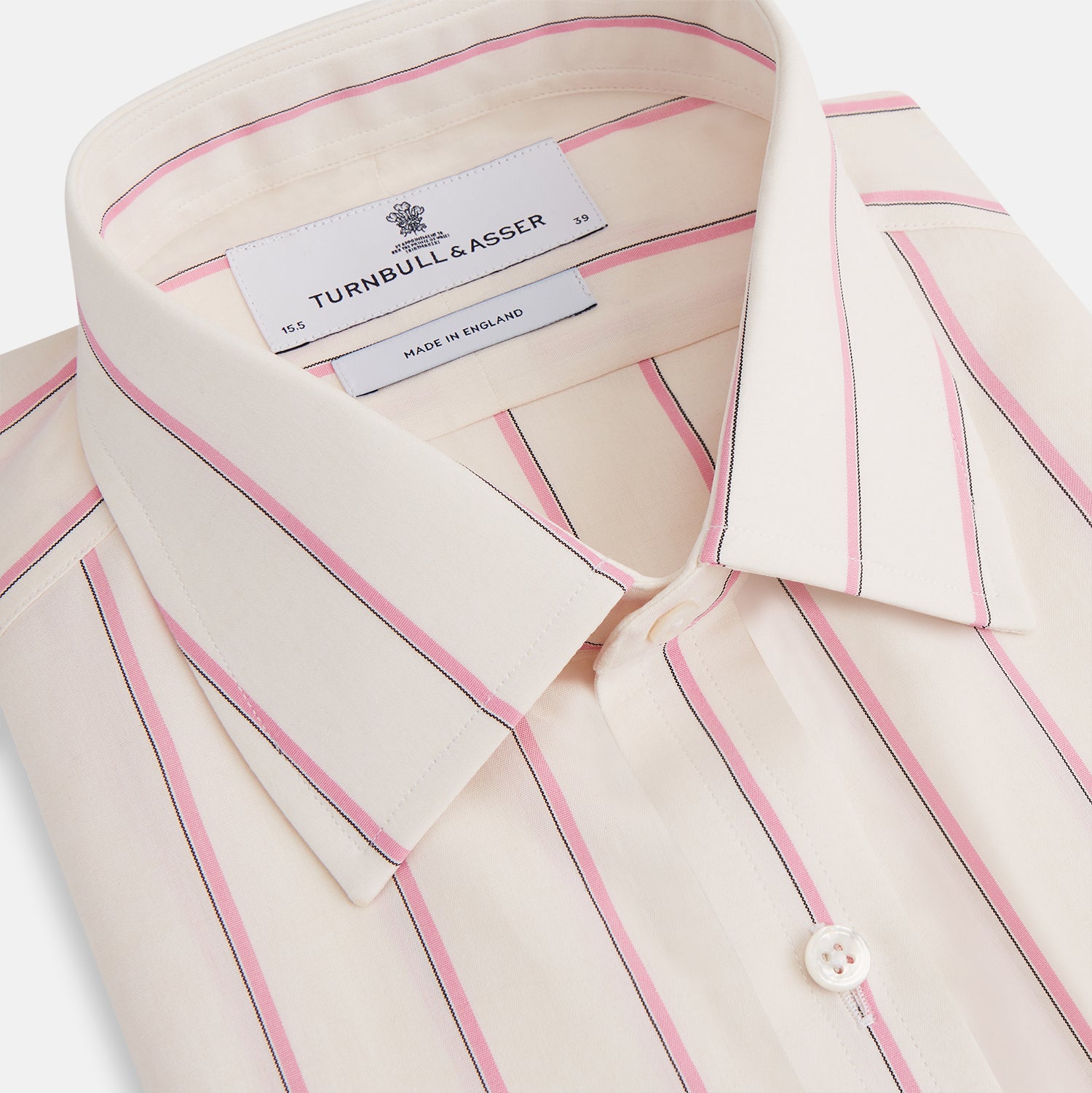 View 2 of product The Turnbull & Asser Pink Track Stripe Mayfair Shirt features long sleeves, a collar, and cream fabric with vertical pink stripes, crafted from breathable cotton and shown on a plain white background.