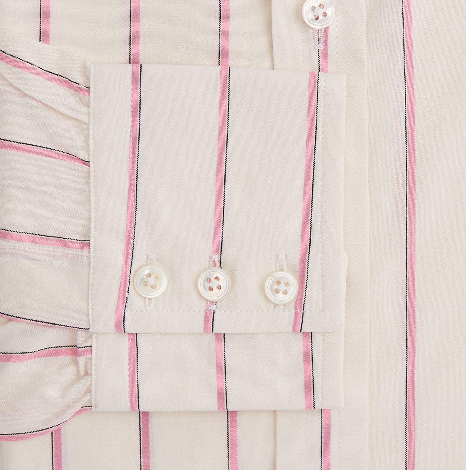 View 3 of product The Turnbull & Asser Pink Track Stripe Mayfair Shirt features long sleeves, a collar, and cream fabric with vertical pink stripes, crafted from breathable cotton and shown on a plain white background.