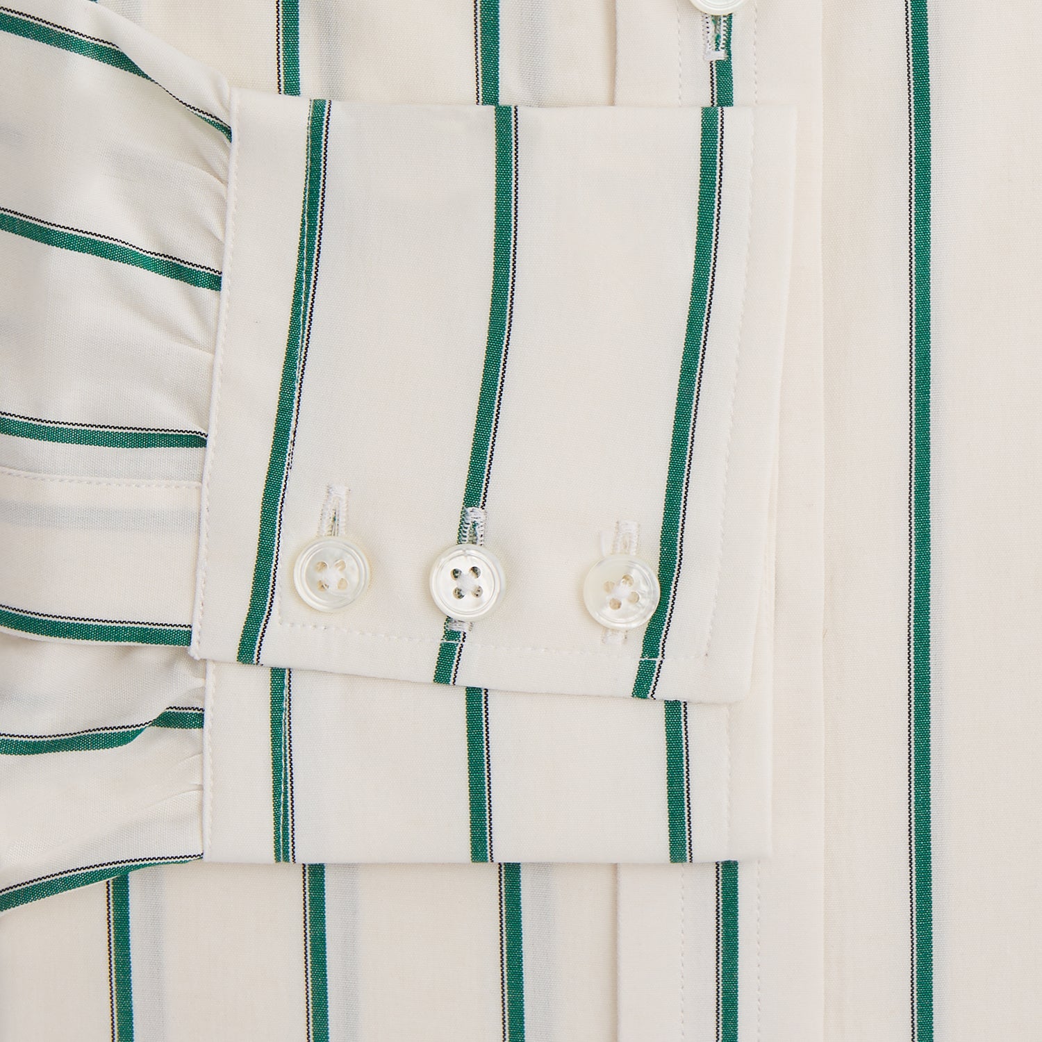 View 3 of product The Turnbull & Asser Green Track Stripe Mayfair Shirt is a long-sleeved, breathable cotton shirt with green vertical stripes, a classic T&A collar, and buttoned cuffs.