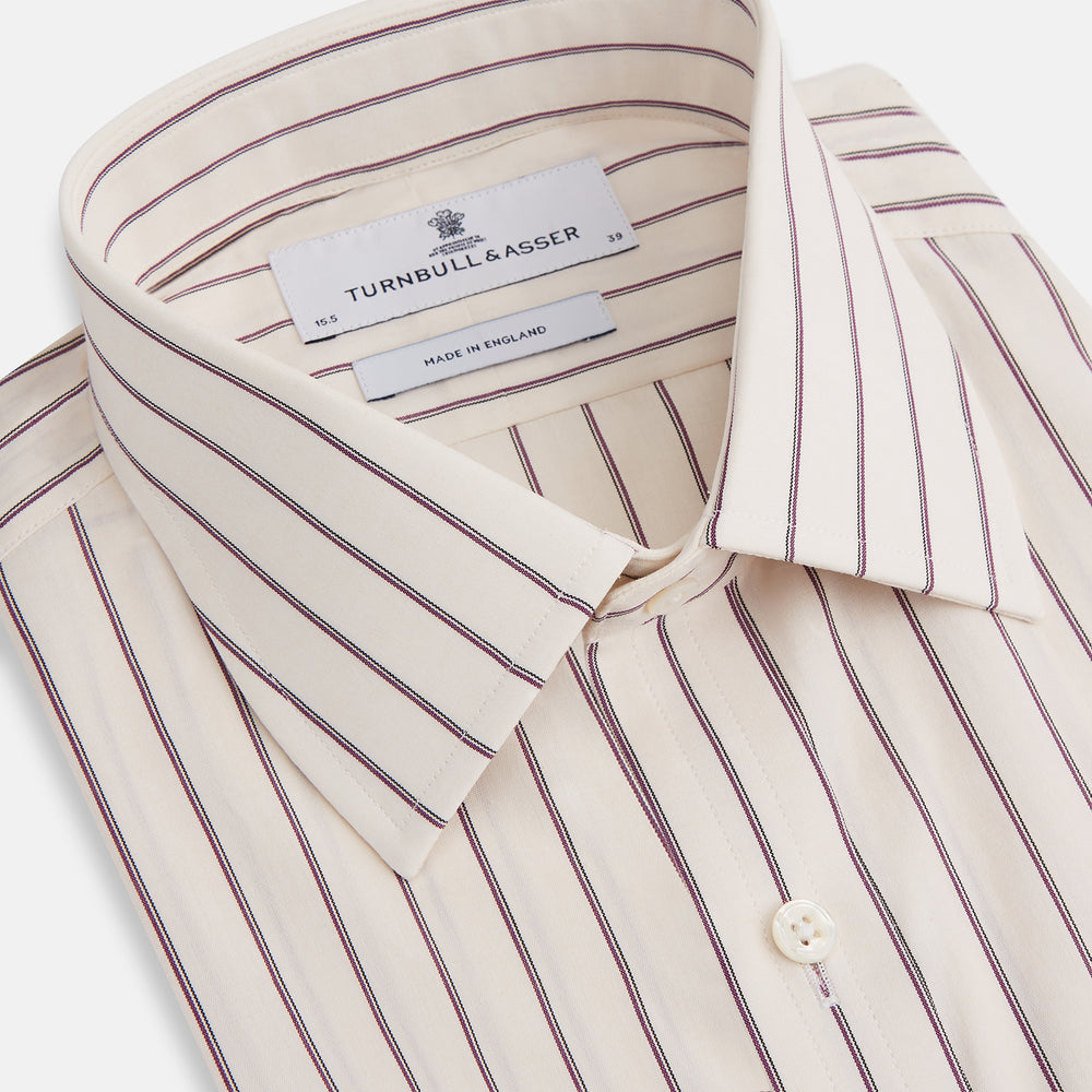 The Purple Halo Stripe Mayfair Shirt by Turnbull & Asser is an organic cotton, long-sleeved shirt with a T&A collar, buttoned cuffs, and thin black stripes on a white base, neatly laid flat on a white background.