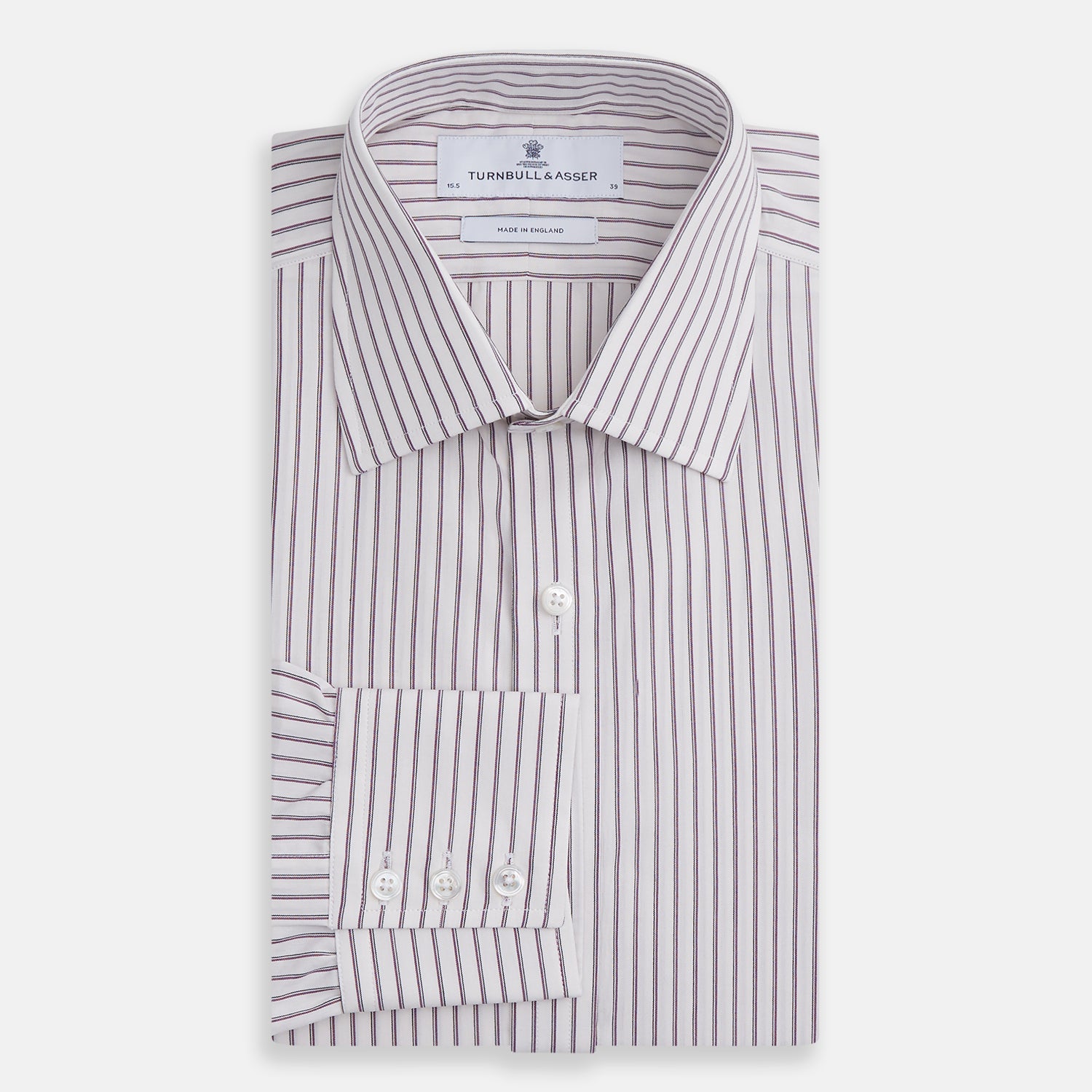 View 4 of product The Turnbull & Asser Purple Track Stripe Mayfair Shirt is a long-sleeve, button-up organic cotton shirt with a T&A collar, showcasing thin vertical black stripes on white and laid flat on a white surface.