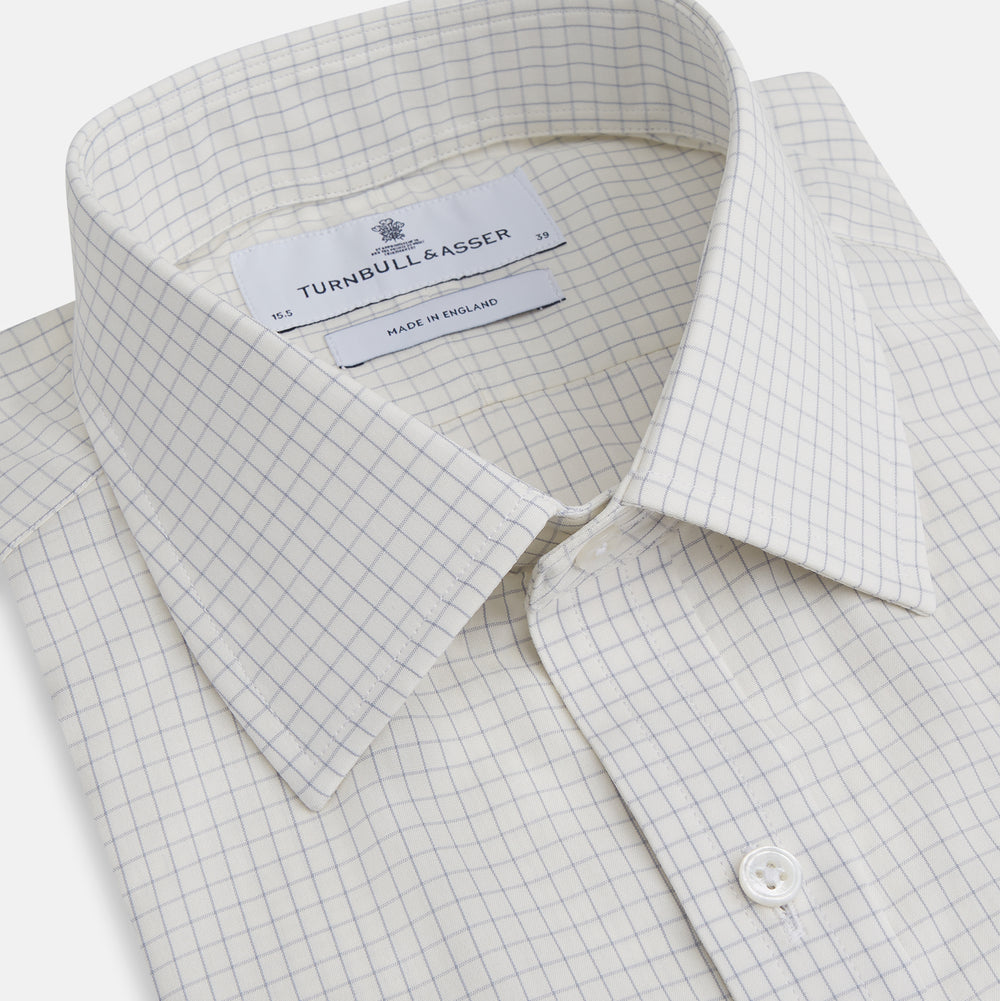 The Turnbull & Asser Pale Blue Graph Check Mayfair Shirt is a long-sleeve, button-up shirt with a pointed collar and buttoned cuffs, crafted from organic cotton—shown here laid flat on a white background.