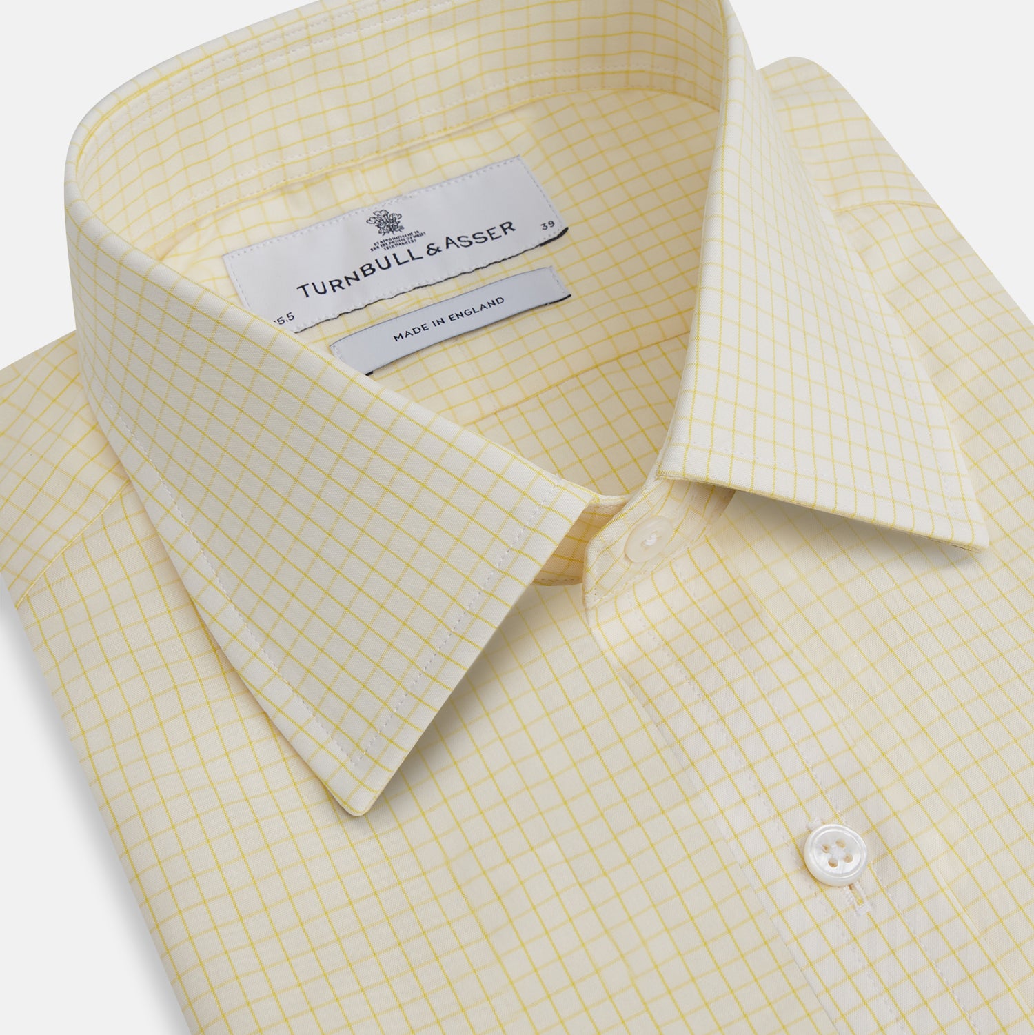 View 2 of product The Turnbull & Asser Yellow Graph Check Mayfair Shirt features long sleeves, a button-up front, and classic T&A collar in organic cotton with a light yellow check pattern—a summer staple shown on a plain white background.