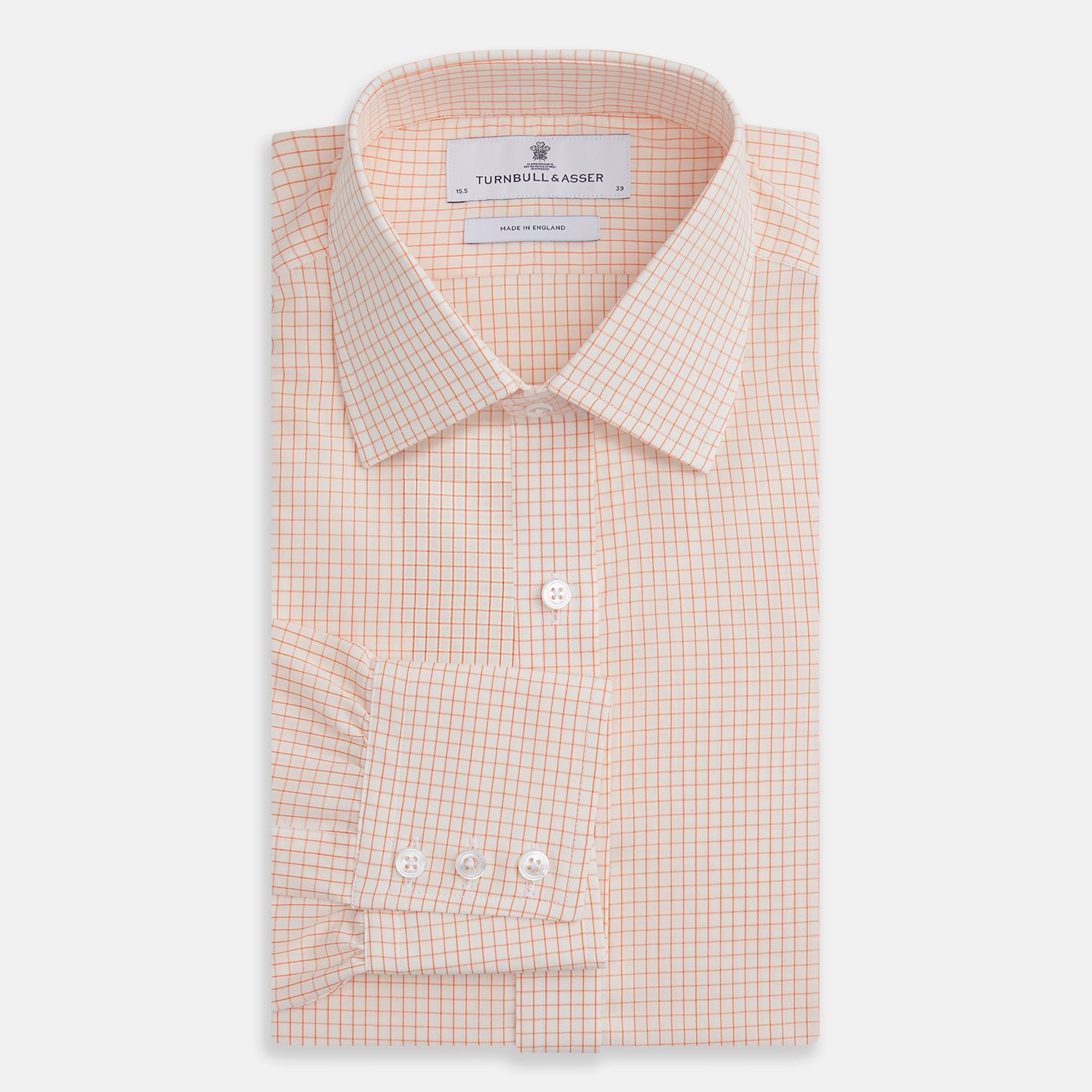 View 4 of product The Turnbull & Asser Orange Graph Check Mayfair Shirt features a classic T&A collar, long sleeves, buttoned cuffs, and a peach and white check pattern, shown against a white background.