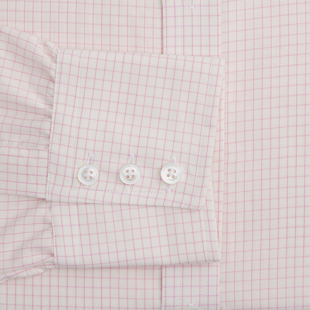 The Pink Graph Check Mayfair Shirt by Turnbull & Asser is an organic cotton, long-sleeve button-down with a classic collar and buttoned cuffs, featuring a subtle light pink and white graph check pattern, shown laid flat on a white background.
