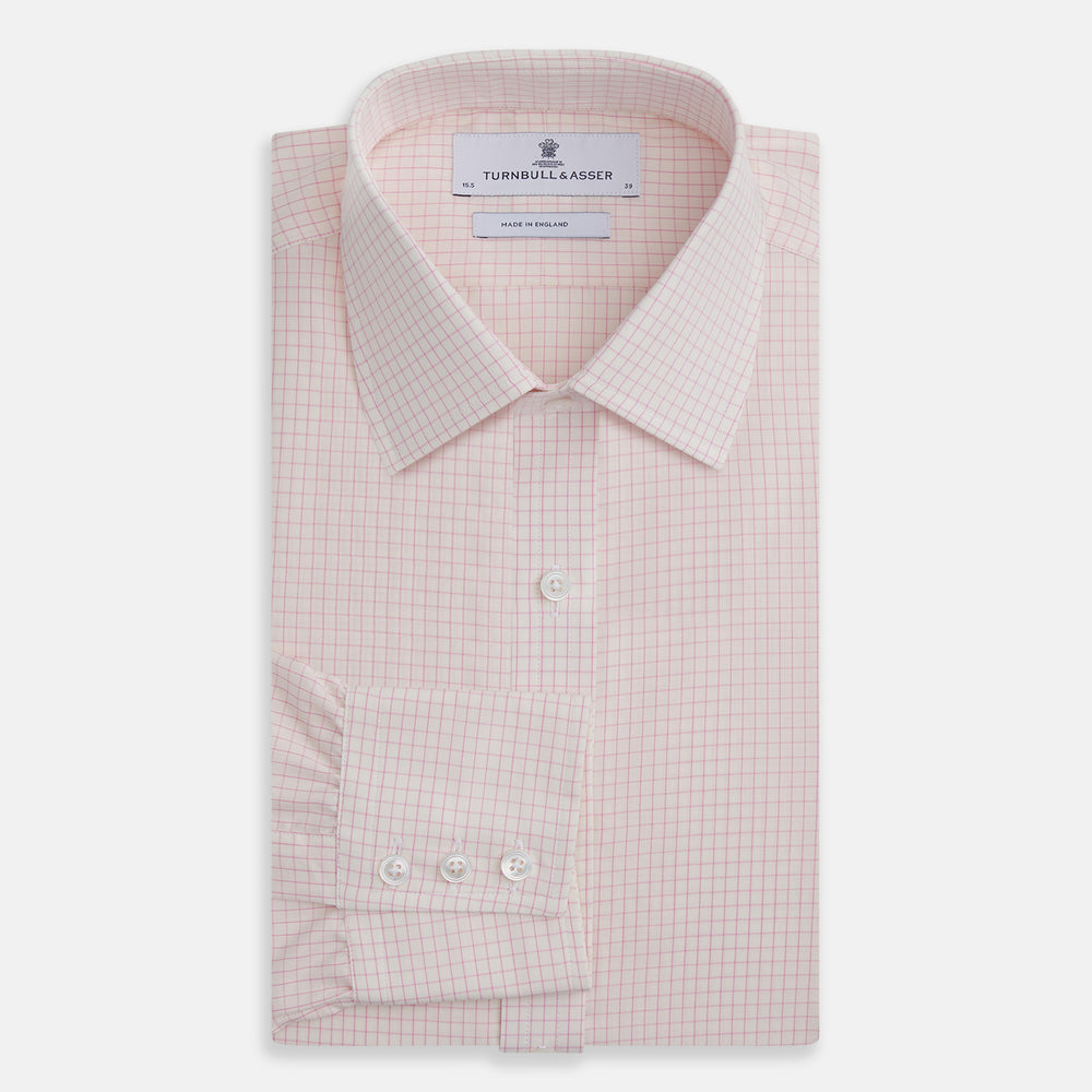 The Pink Graph Check Mayfair Shirt by Turnbull & Asser is an organic cotton, long-sleeve button-down with a classic collar and buttoned cuffs, featuring a subtle light pink and white graph check pattern, shown laid flat on a white background.