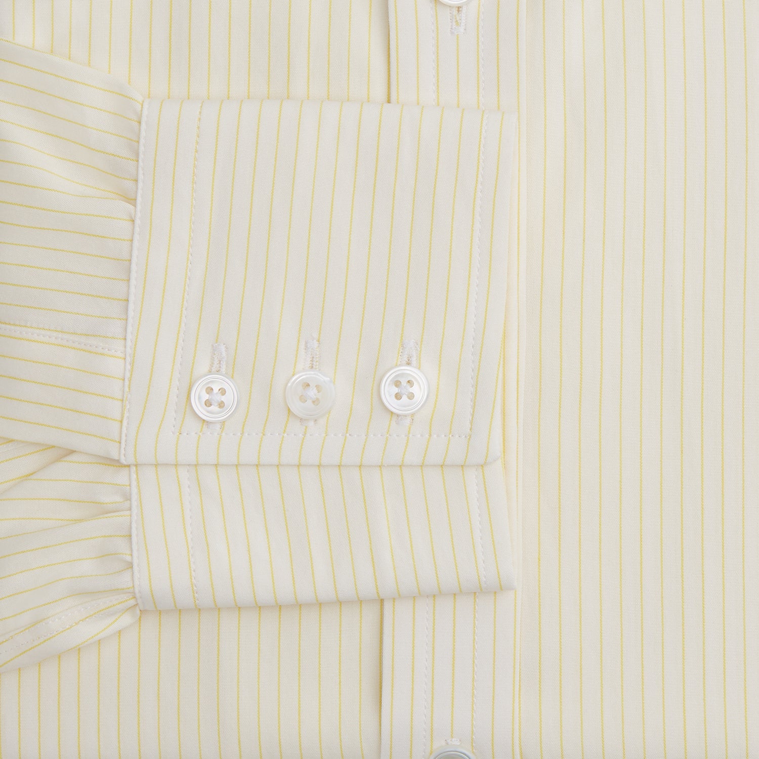 View 3 of product The Turnbull & Asser Yellow Pinstripe Mayfair Shirt, made from organic cotton with long sleeves, a T&A collar, and front buttons, features subtle vertical stripes and is shown on a plain white background.