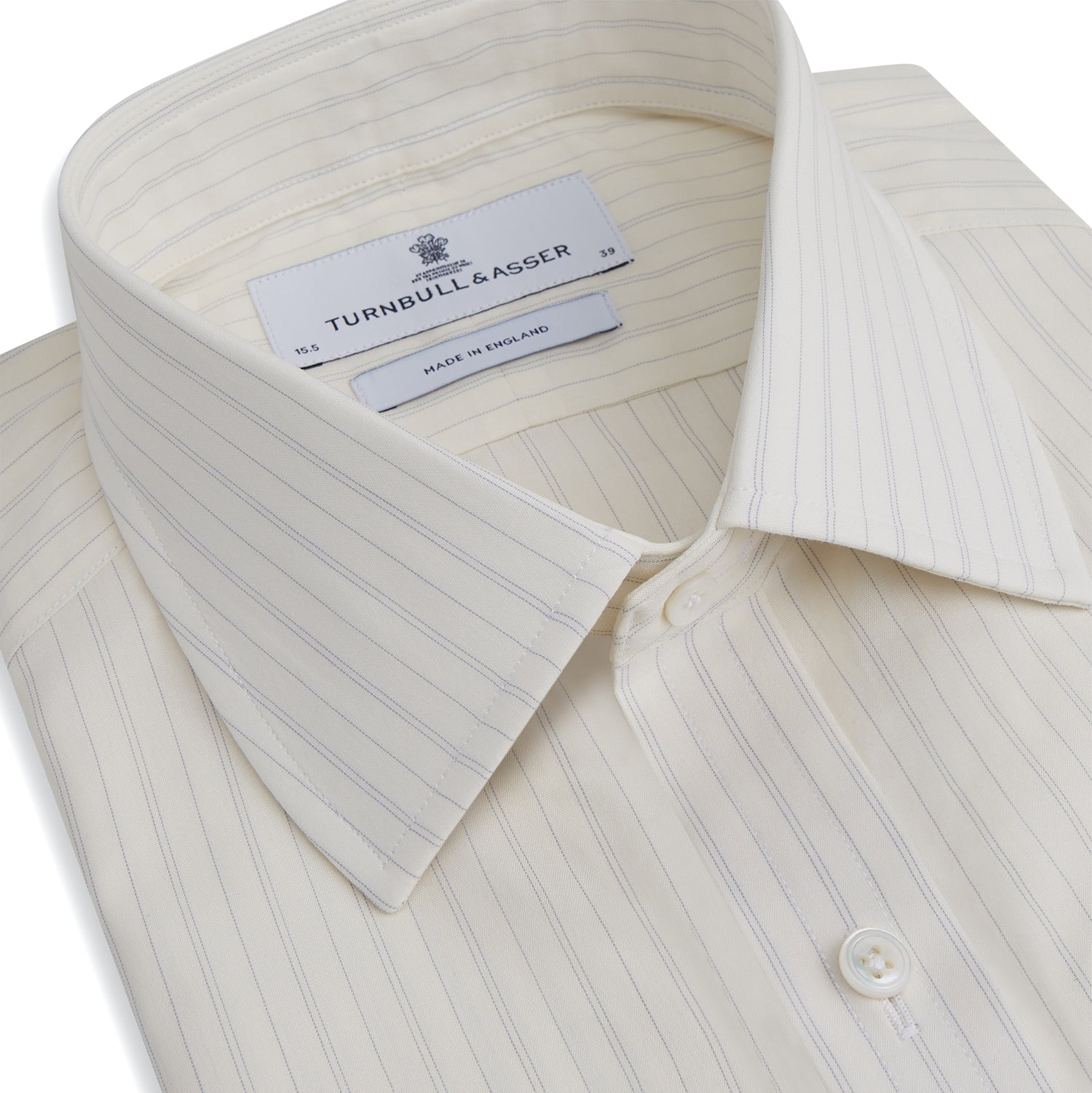 View 2 of product The Turnbull & Asser Pale Blue Fine Track Stripe Mayfair Shirt is a long-sleeve, cream-colored organic cotton shirt with subtle pale blue stripes, a T&A collar, and buttoned cuffs, shown on a plain white background.