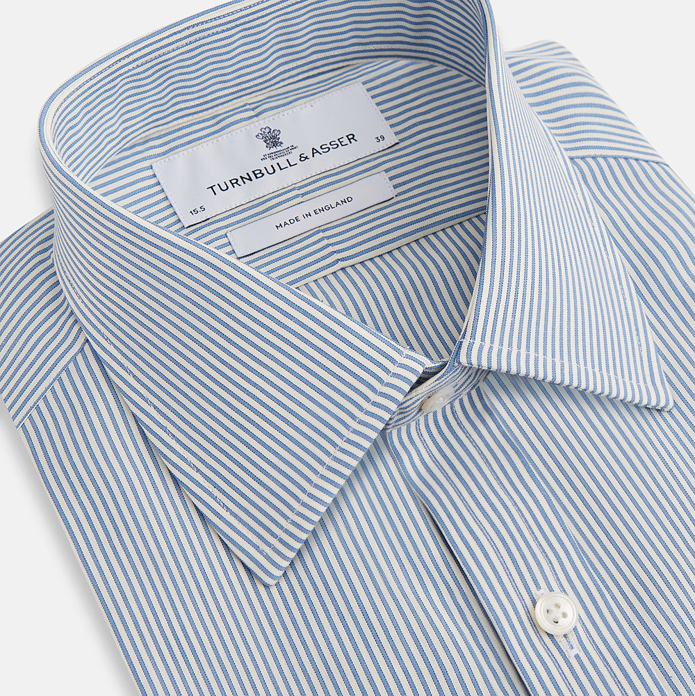 The Turnbull & Asser Blue and White Pencil Stripe Mayfair Shirt features breathable cotton, a standard collar, buttoned cuffs, and white buttons, shown laid flat on a white background.