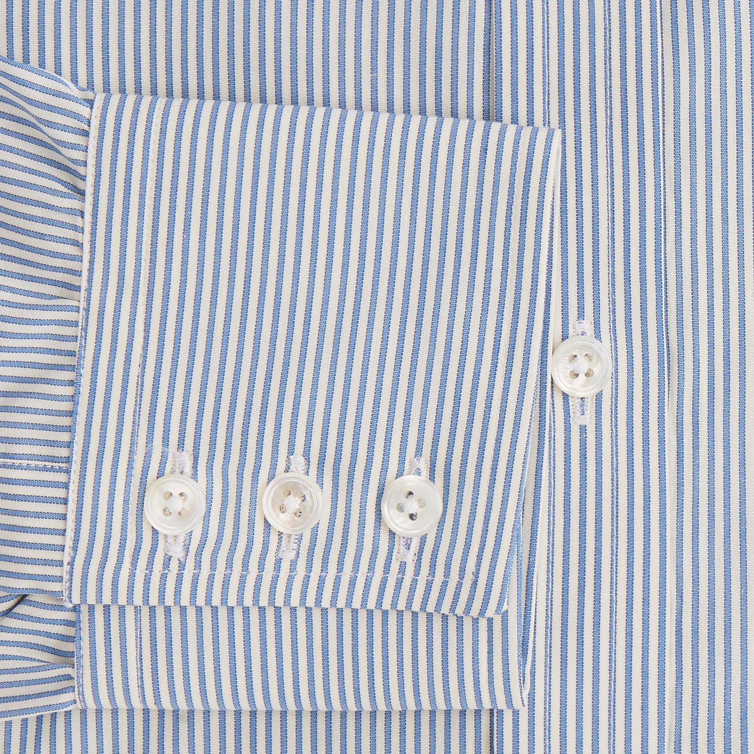 View 3 of product The Turnbull & Asser Blue and White Pencil Stripe Mayfair Shirt features breathable cotton, a standard collar, buttoned cuffs, and white buttons, shown laid flat on a white background.