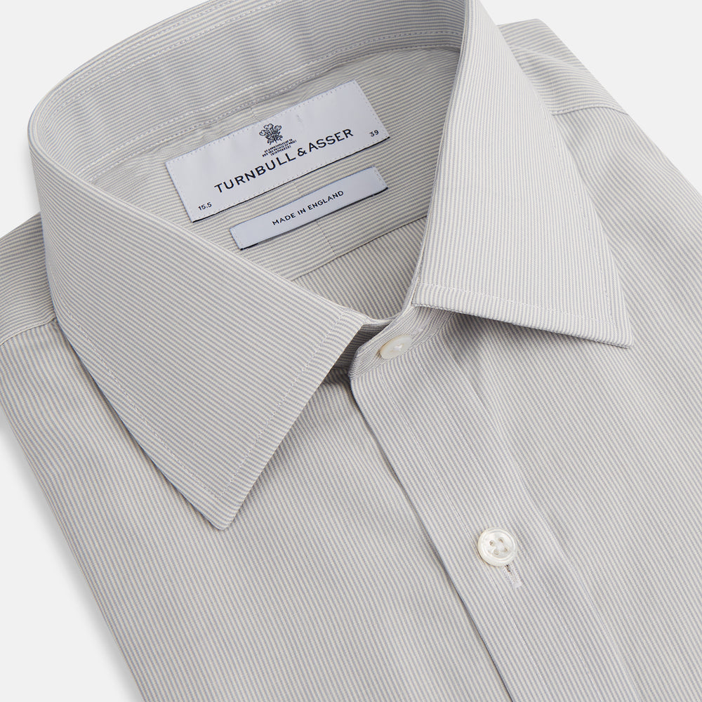 The Turnbull & Asser Pale Blue Fine Stripe Mayfair Shirt features a classic collar, white buttons, cuffs, a slightly curved hem, and subtle pale blue stripes for a formal tailored look. Displayed on a plain white background.