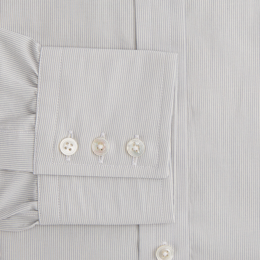 The Turnbull & Asser Pale Blue Fine Stripe Mayfair Shirt features a classic collar, white buttons, cuffs, a slightly curved hem, and subtle pale blue stripes for a formal tailored look. Displayed on a plain white background.