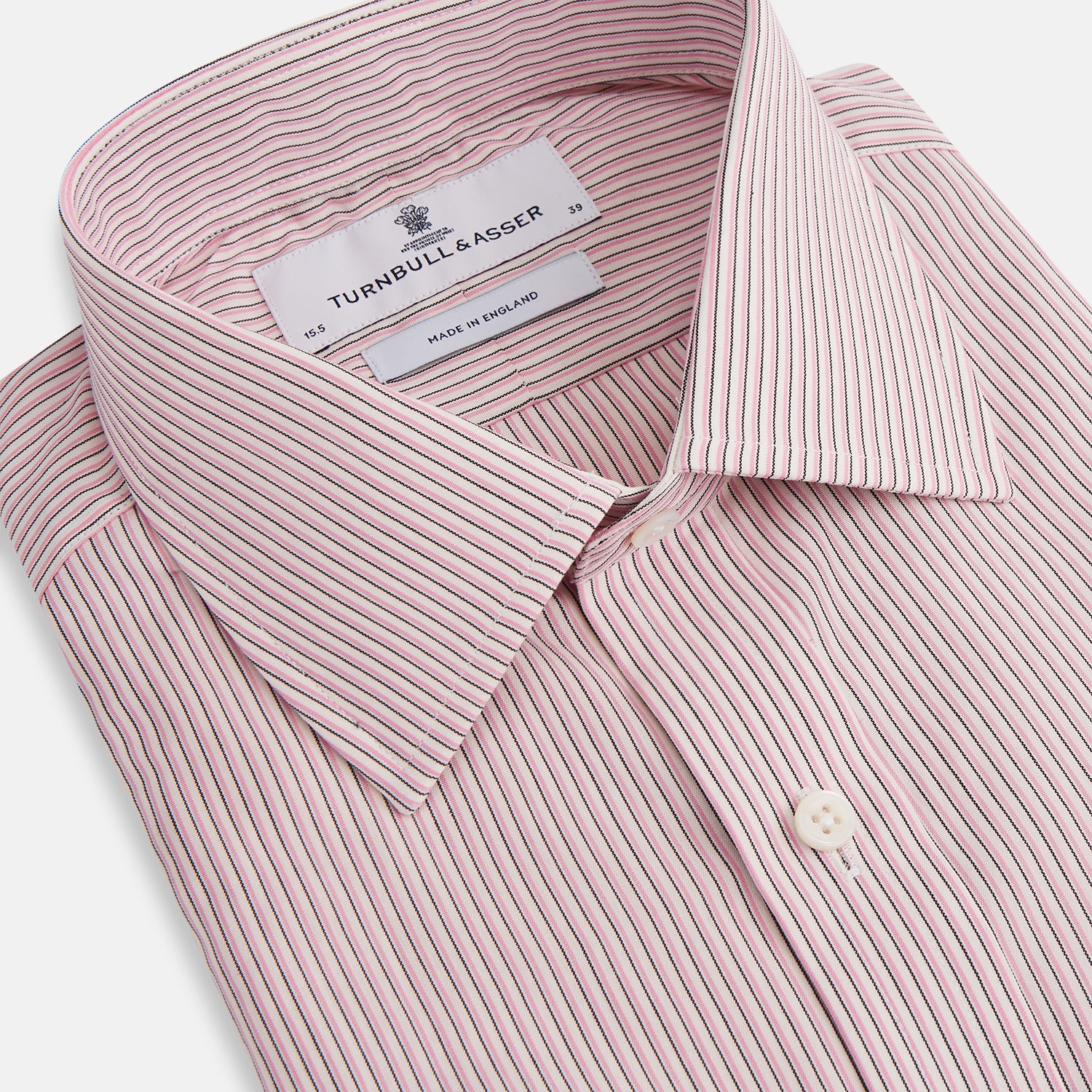 View 2 of product The Turnbull & Asser Pink Fine Shadow Stripe Mayfair Shirt is a long-sleeved button-up with a classic T&A collar, crafted from pure cotton and featuring thin pink and white vertical stripes, shown on a plain white background.