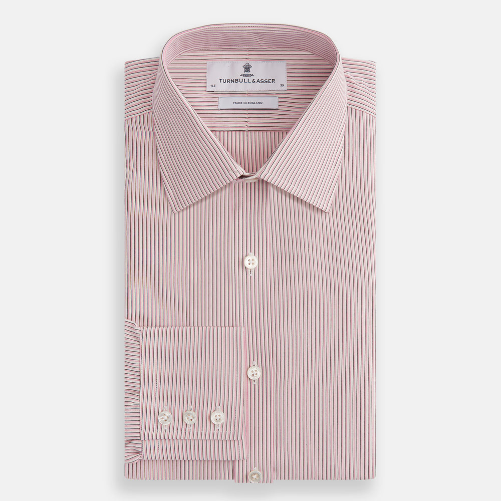 The Turnbull & Asser Pink Fine Shadow Stripe Mayfair Shirt is a long-sleeved button-up with a classic T&A collar, crafted from pure cotton and featuring thin pink and white vertical stripes, shown on a plain white background.