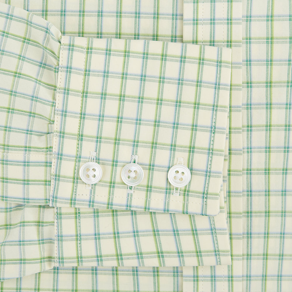 The Turnbull & Asser Green Multi Check Mayfair Shirt features a light green and white checkered pattern, long sleeves, a collar, and buttoned cuffs. Displayed on a white background.