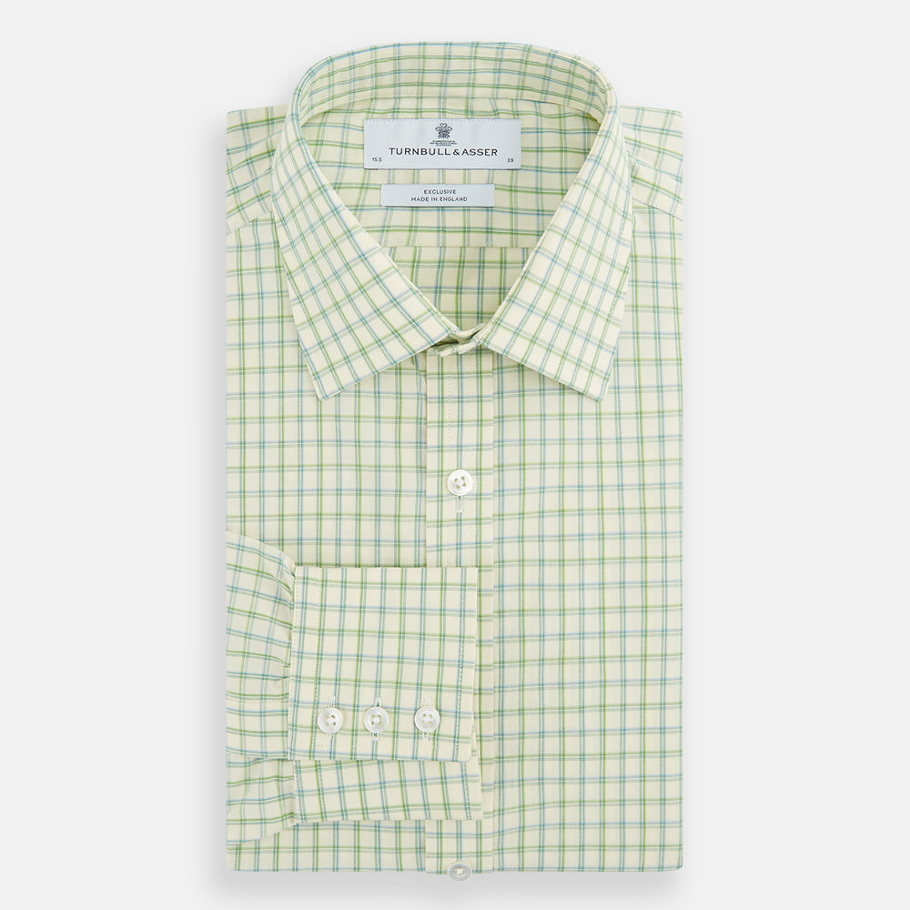 The Turnbull & Asser Green Multi Check Mayfair Shirt features a light green and white checkered pattern, long sleeves, a collar, and buttoned cuffs. Displayed on a white background.