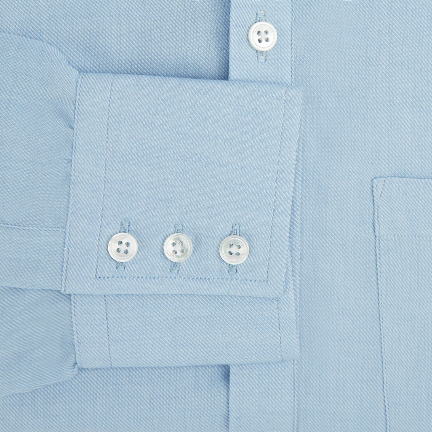 View 3 of product The Blue Cotton Cashmere Chelsea Shirt by Turnbull & Asser, a light blue long-sleeve button-up with a chest pocket, crafted from soft cotton and cashmere, is shown laid flat on a white background.