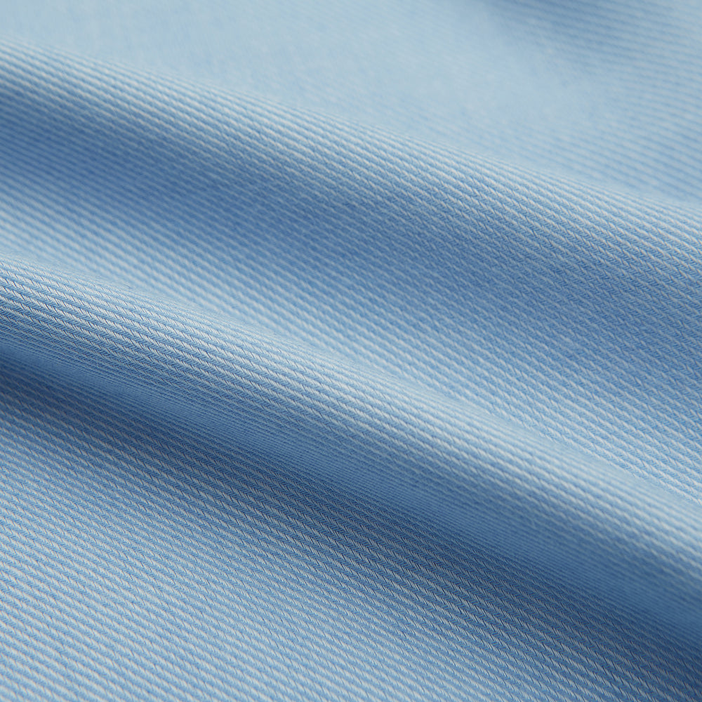 The Blue Cotton Cashmere Chelsea Shirt by Turnbull & Asser, a light blue long-sleeve button-up with a chest pocket, crafted from soft cotton and cashmere, is shown laid flat on a white background.