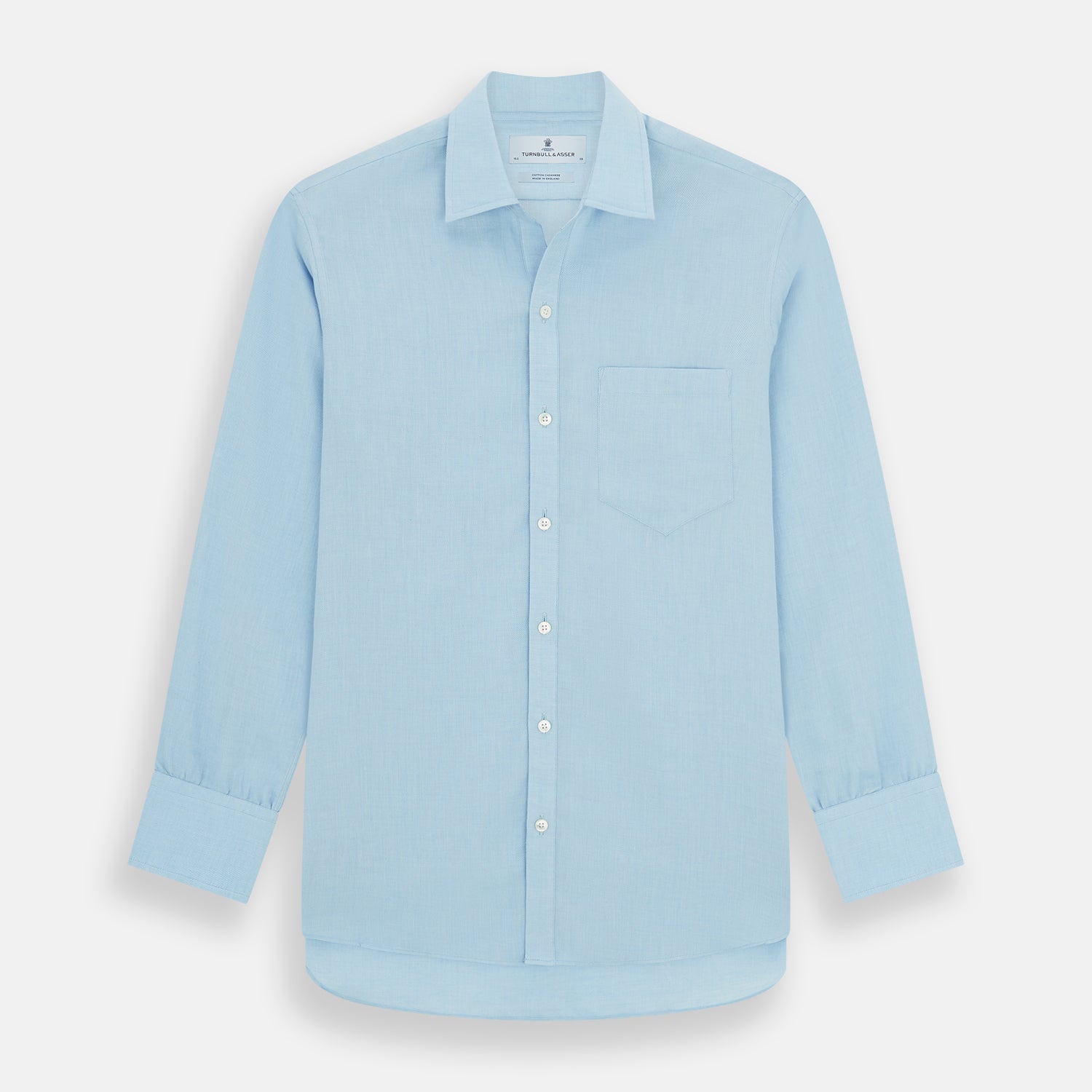 View 1 of product The Blue Cotton Cashmere Chelsea Shirt by Turnbull & Asser, a light blue long-sleeve button-up with a chest pocket, crafted from soft cotton and cashmere, is shown laid flat on a white background.