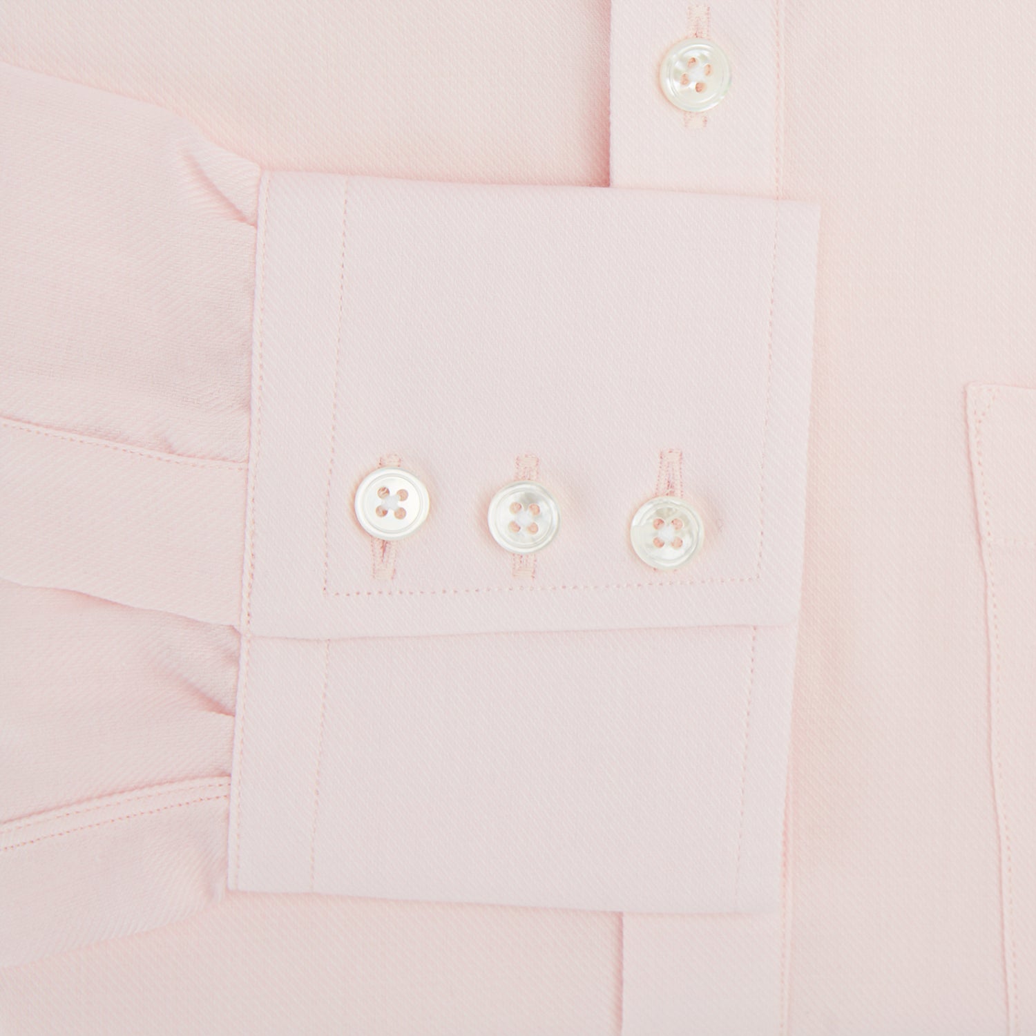 View 3 of product The Turnbull & Asser Pale Pink Cotton Cashmere Chelsea Shirt features long sleeves, a chest pocket, spread collar, and buttoned cuffs. Crafted from a luxurious cotton-cashmere blend, it's shown laid flat on a white background.