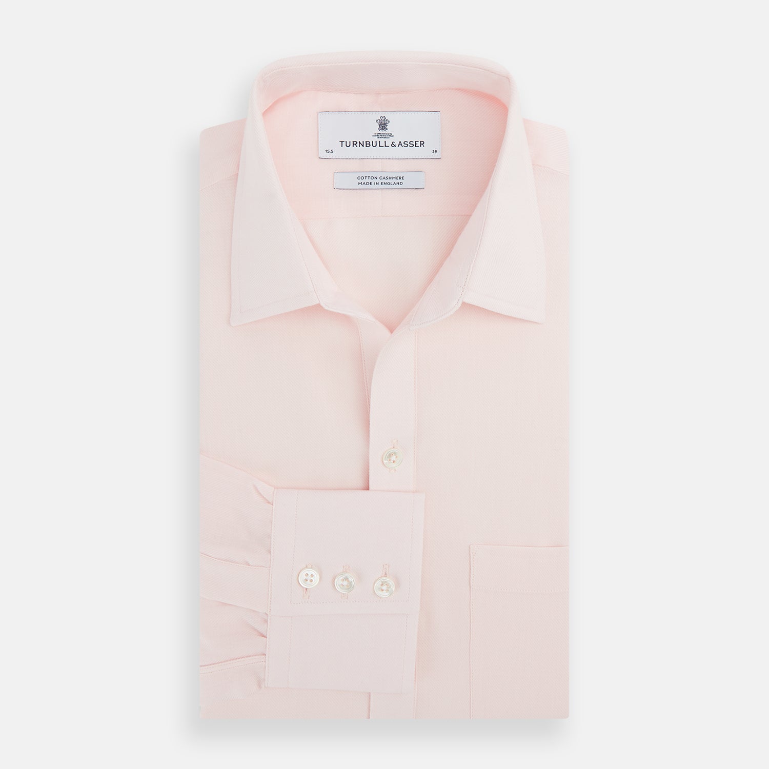 View 4 of product The Turnbull & Asser Pale Pink Cotton Cashmere Chelsea Shirt features long sleeves, a chest pocket, spread collar, and buttoned cuffs. Crafted from a luxurious cotton-cashmere blend, it's shown laid flat on a white background.