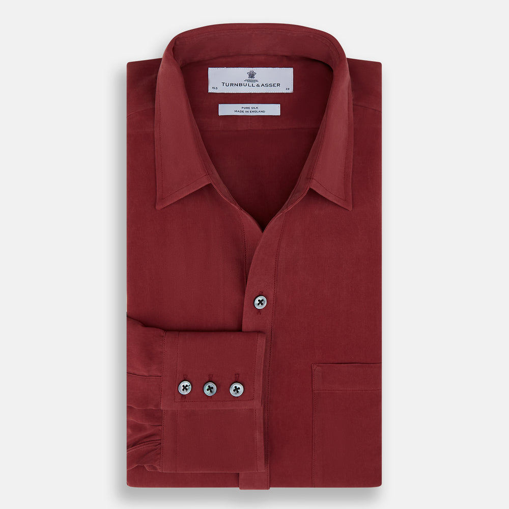 The Turnbull & Asser Burgundy Silk Chelsea Shirt is a long-sleeve, button-up top with a single chest pocket, shown on a white background.