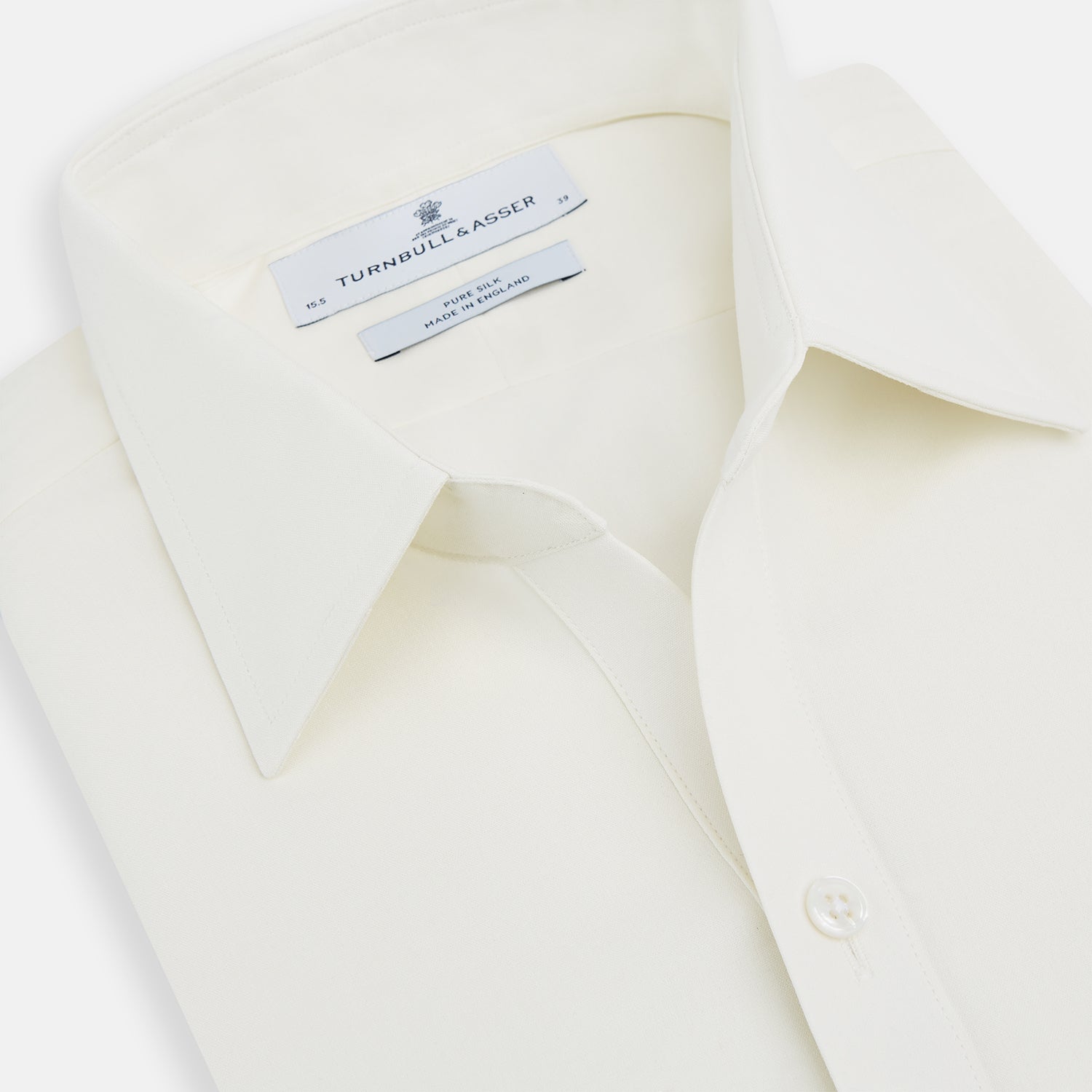 View 2 of product The Turnbull & Asser Cream Silk Chelsea Shirt is an elegant white long-sleeve, button-up silk shirt with a single chest pocket, shown against a plain white background.