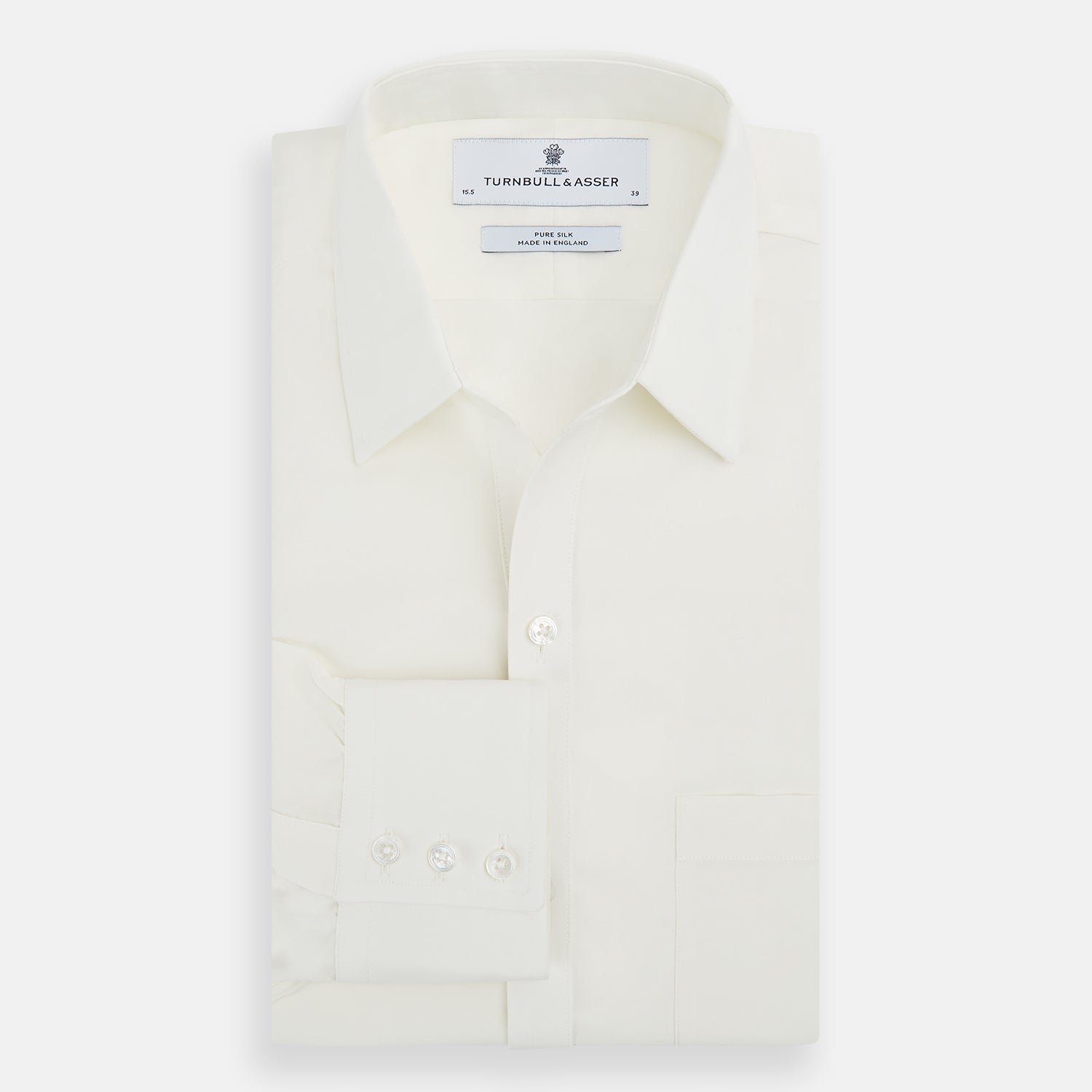 View 5 of product The Turnbull & Asser Cream Silk Chelsea Shirt is an elegant white long-sleeve, button-up silk shirt with a single chest pocket, shown against a plain white background.