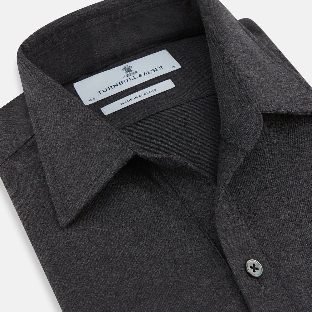 The Charcoal Chelsea Shirt by Turnbull & Asser is a long-sleeve, collared shirt in charcoal gray with a single chest pocket, offering smart-casual style, shown on a plain white background.