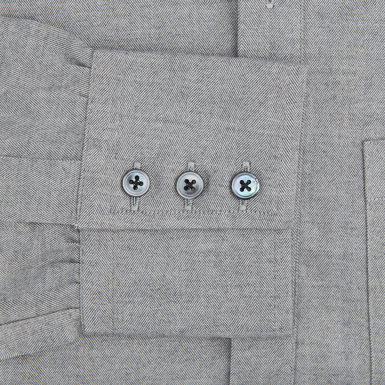 View 3 of product The Turnbull & Asser Grey Herringbone Chelsea Shirt features long sleeves, a chest pocket, classic collar, and buttoned cuffs, adding refined style to smart-casual outfits—shown here against a plain white background.