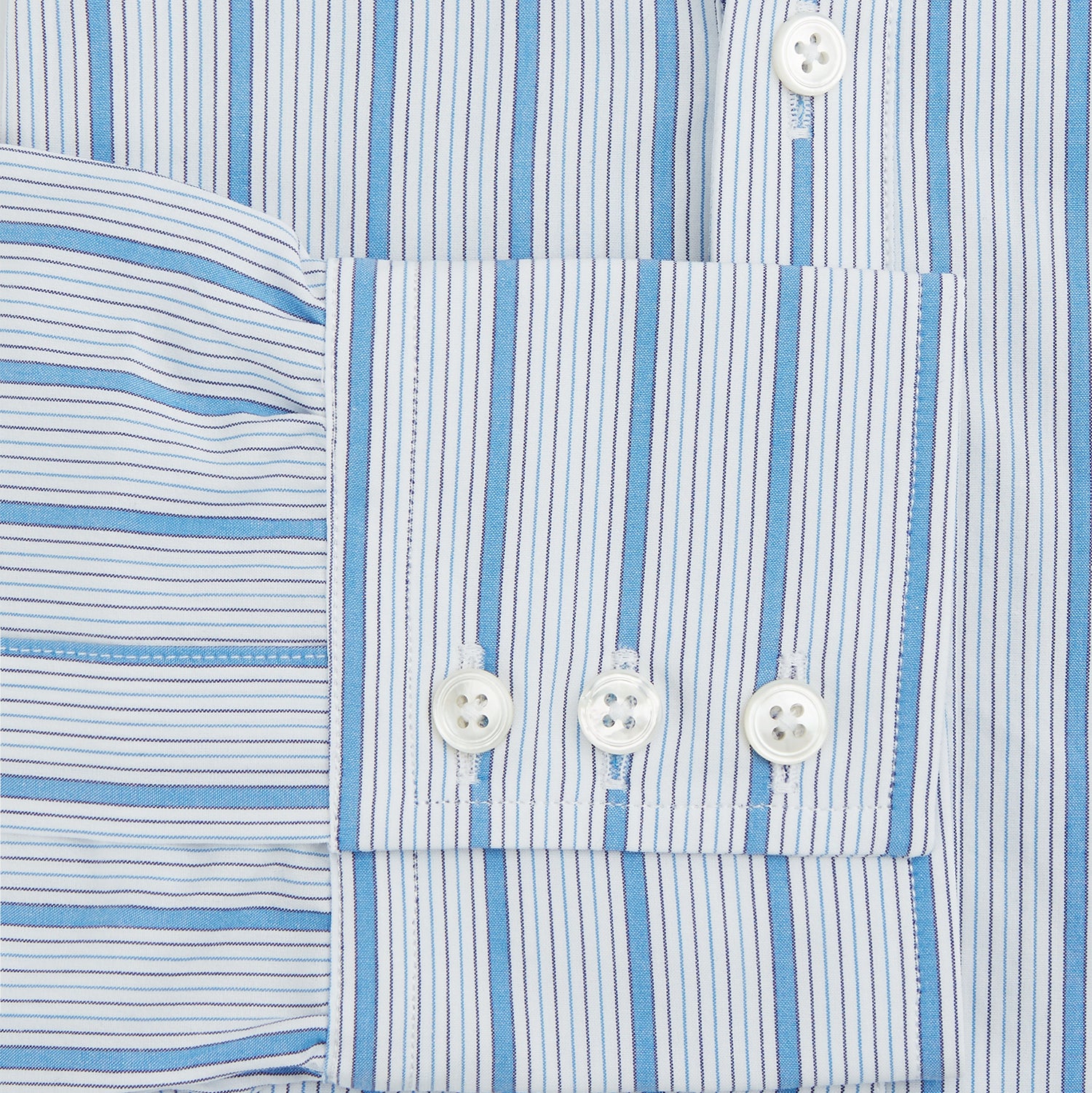 View 3 of product The Turnbull & Asser Blue Multi Track Stripe Chelsea Shirt features long sleeves, a light blue multi-stripe design, a chest pocket, open collar, and buttoned cuffs, shown laid flat on a white background.
