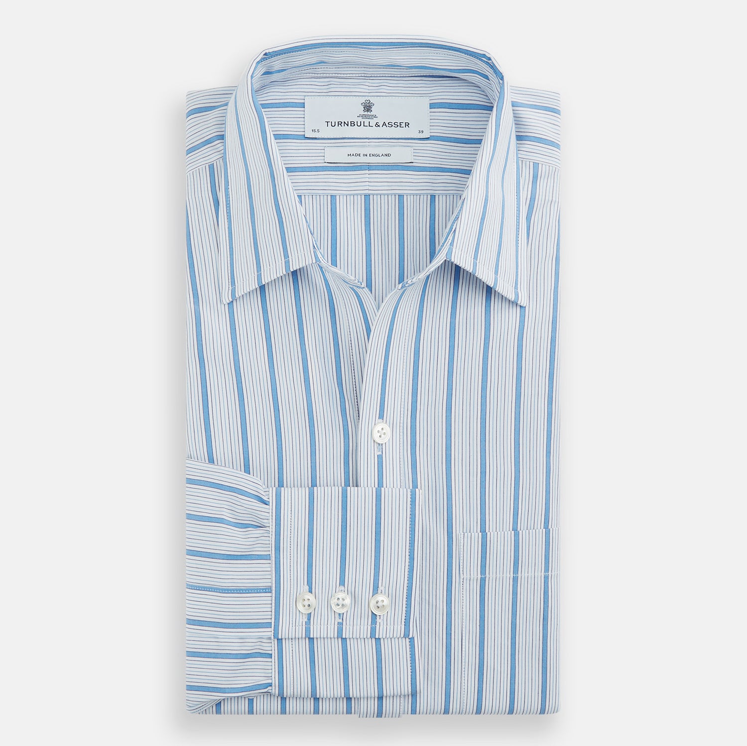 View 5 of product The Turnbull & Asser Blue Multi Track Stripe Chelsea Shirt features long sleeves, a light blue multi-stripe design, a chest pocket, open collar, and buttoned cuffs, shown laid flat on a white background.