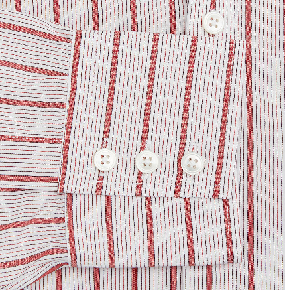 The Turnbull & Asser Red Multi Track Stripe Chelsea Shirt features a classic open collar, long sleeves, red vertical stripes on white, and a left chest pocket—laid flat against a plain background.