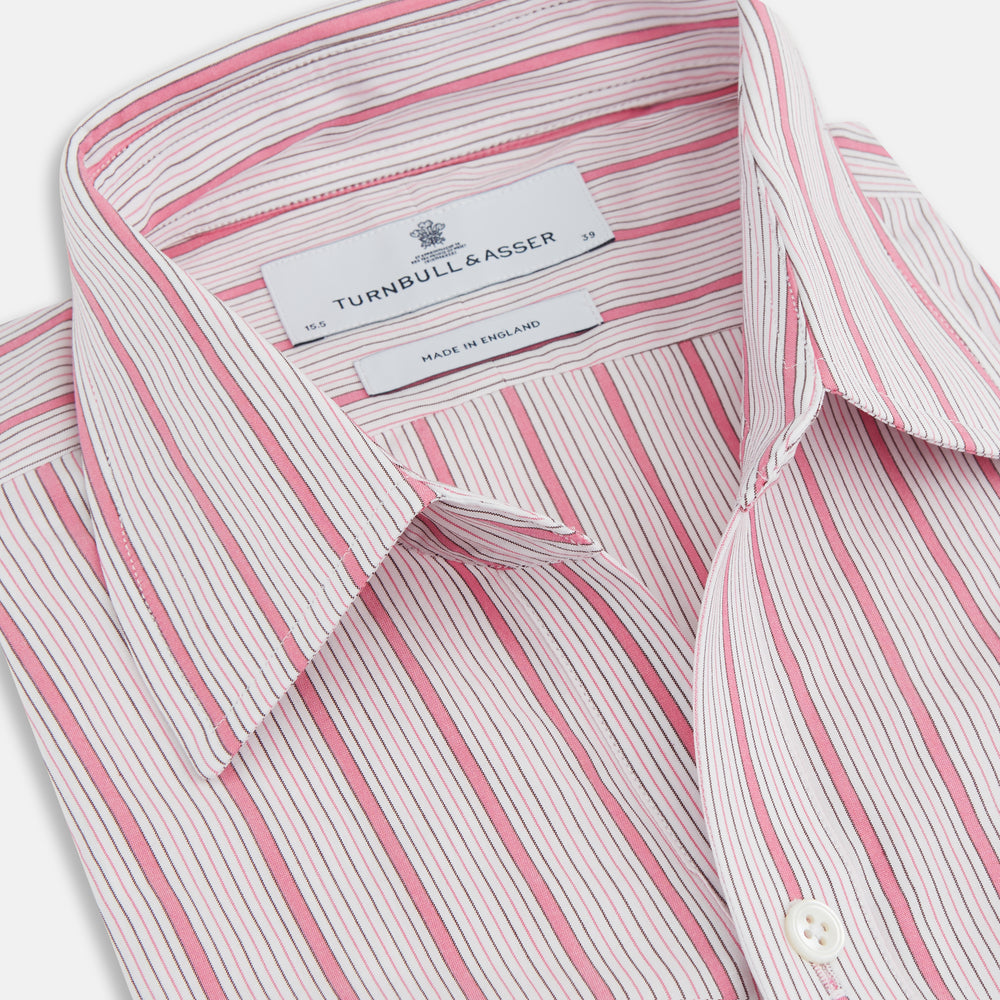 The Turnbull & Asser Pink Multi Track Stripe Chelsea Shirt features long sleeves, an open T&A collar, a left chest pocket, and buttoned cuffs, shown laid flat on a white background.