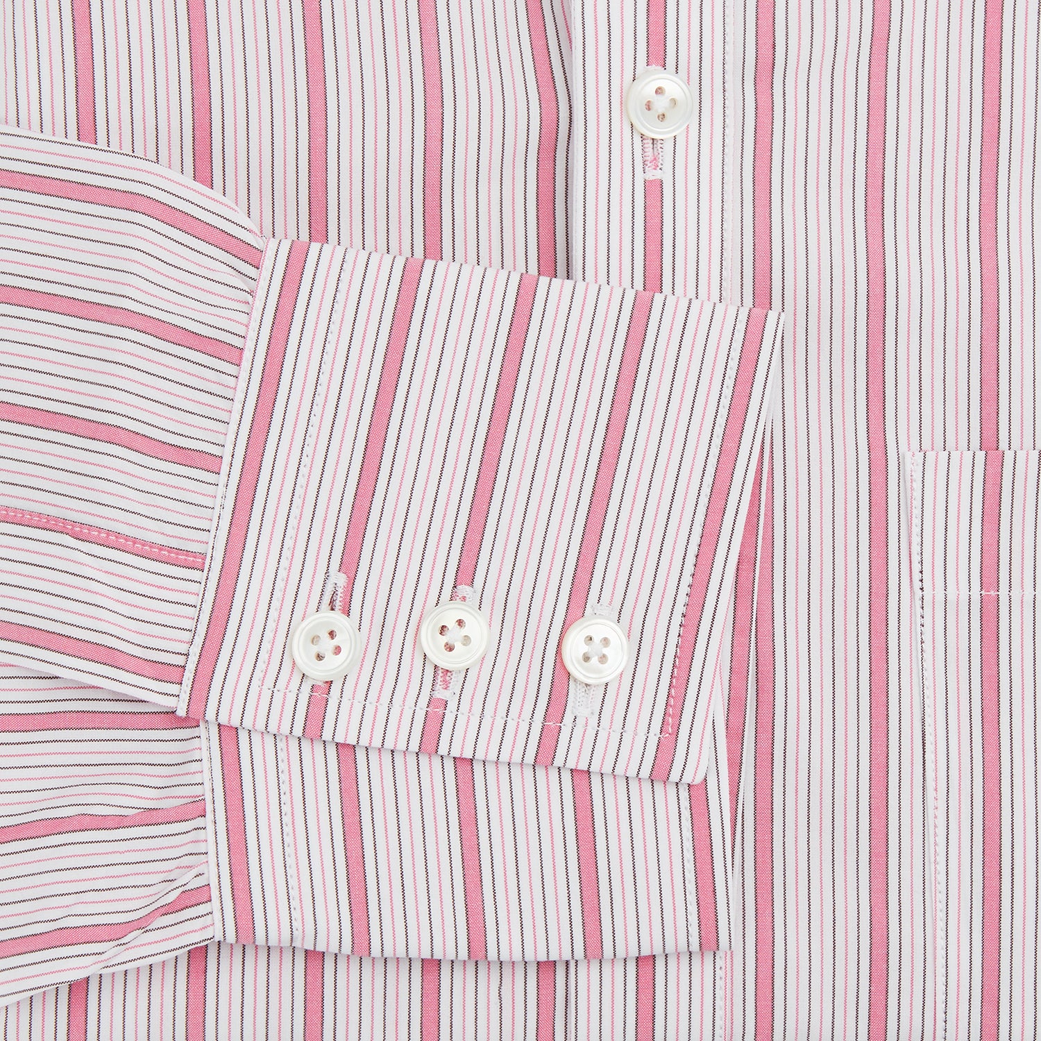 View 3 of product The Turnbull & Asser Pink Multi Track Stripe Chelsea Shirt features long sleeves, an open T&A collar, a left chest pocket, and buttoned cuffs, shown laid flat on a white background.